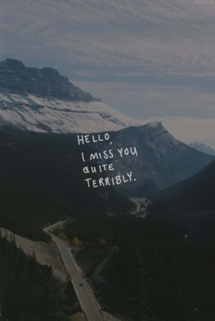I Miss You 桌布 壁紙 — 一條蜿蜒的山路穿過森林覆蓋的山谷，下方是白雪覆蓋的山峰，天空中漂浮著手寫訊息。