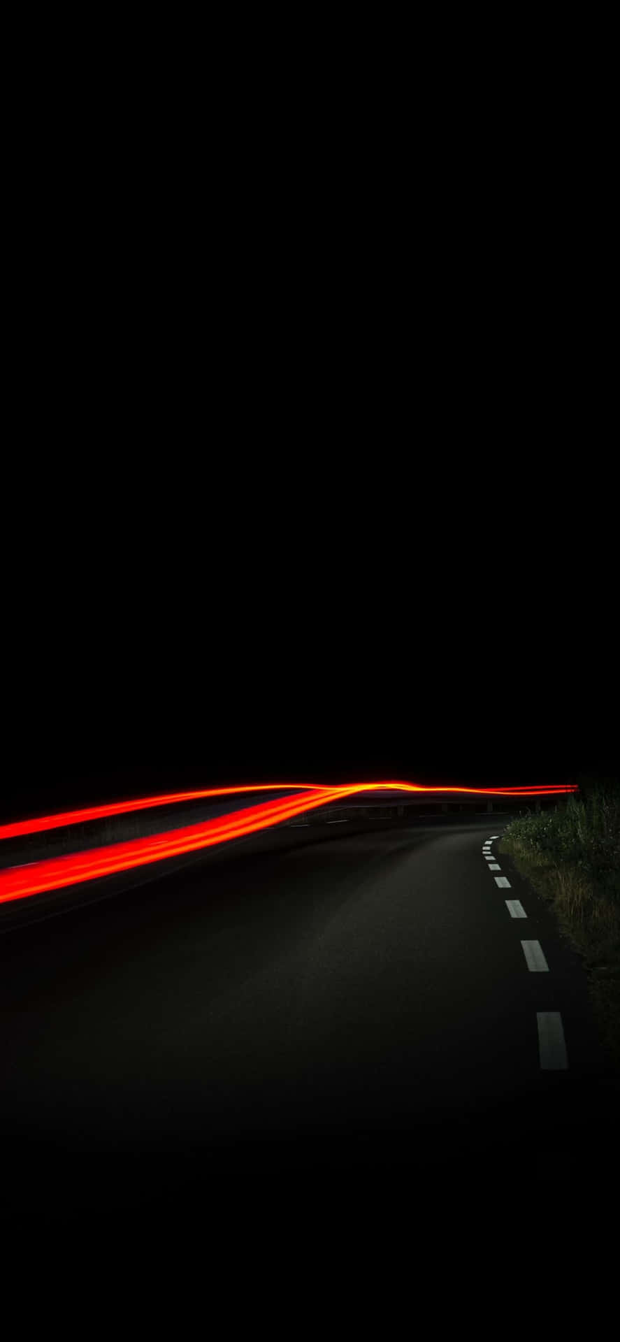 time lapse 桌布 壁紙 — 一條蜿蜒的道路在夜晚被移動車輛的鮮豔紅色和橙色光軌照亮，背景是漆黑的天空。