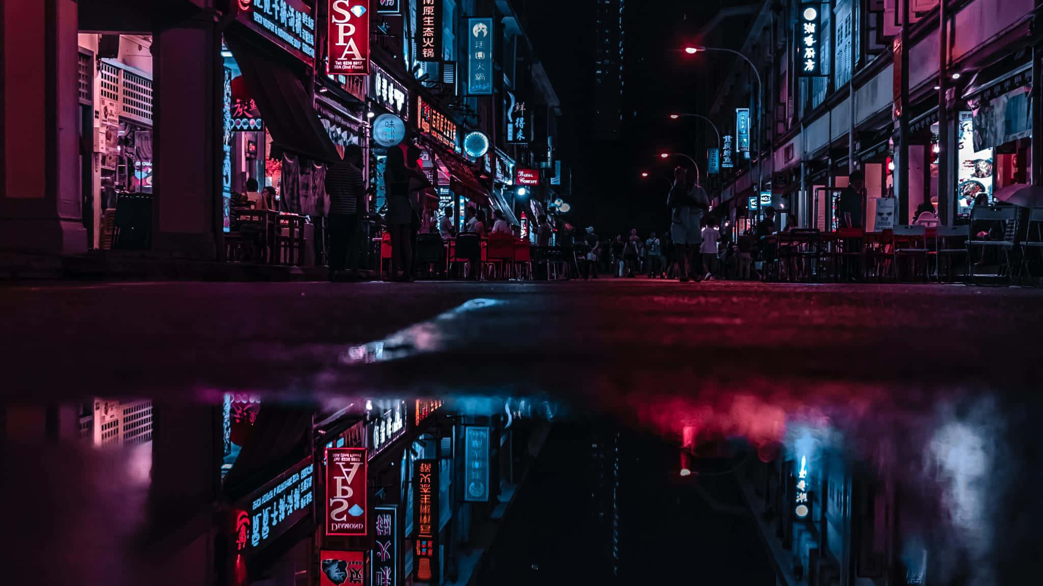 Dark Crossroad 桌布 壁紙 — 一條被霓虹燈浸透的都市街道在夜晚倒映在雨水中，映照出發光的招牌和剪影般的行人。