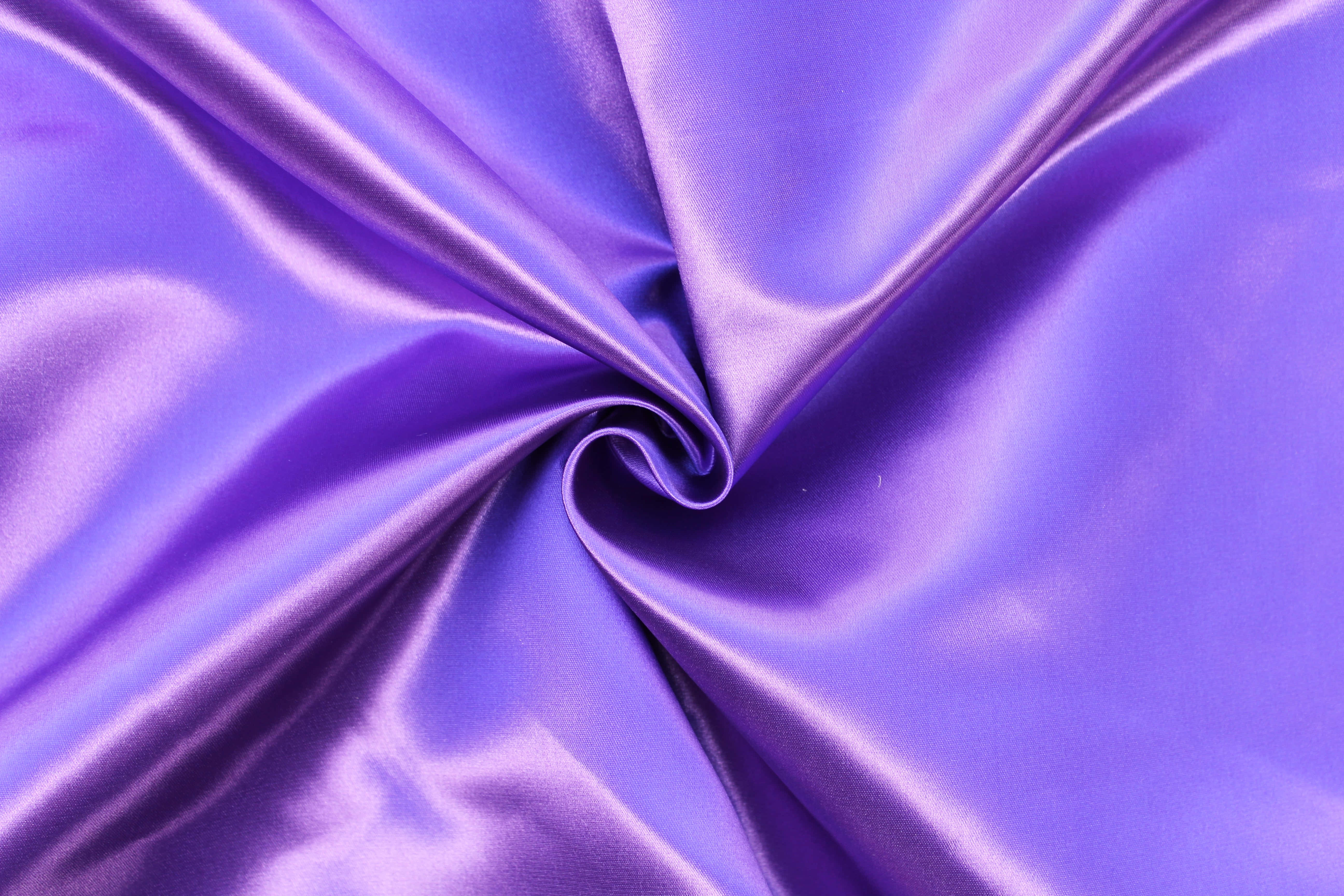 Purple Satin 桌布 壁紙 — 一條豪華的紫色緞布在柔軟的褶皺中旋轉，捕捉光線，呈現出光澤的光澤。