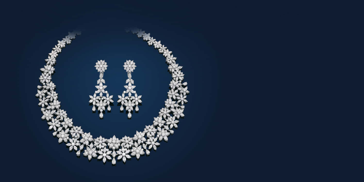 Jewelry Design 桌布 壁紙 — 一條閃耀的鑽石項鍊和配套的耳環，在深藍色背景上排列成花卉圖案。