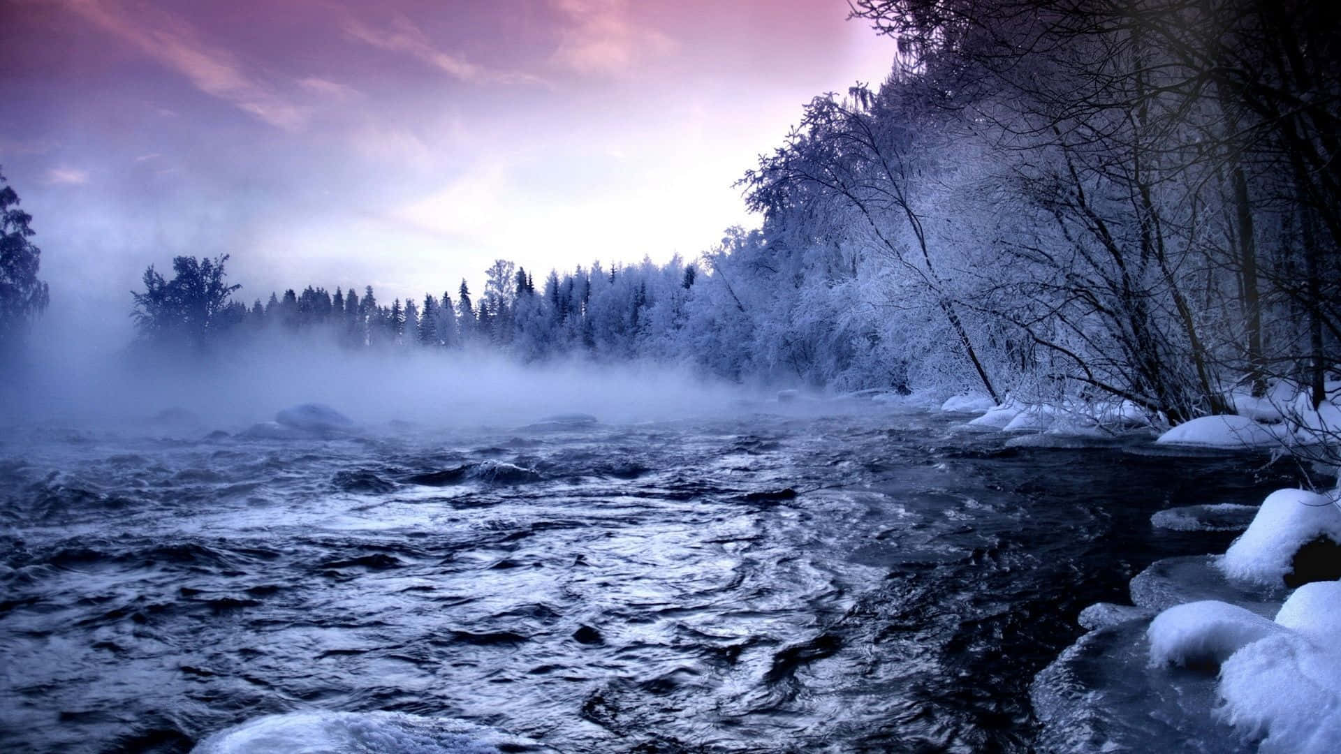 Snowy Landscape 桌布 壁紙 — 一條霧氣瀰漫的冬日河流，流過白雪覆蓋的樹木，在紫色和藍色的暮色天空下。