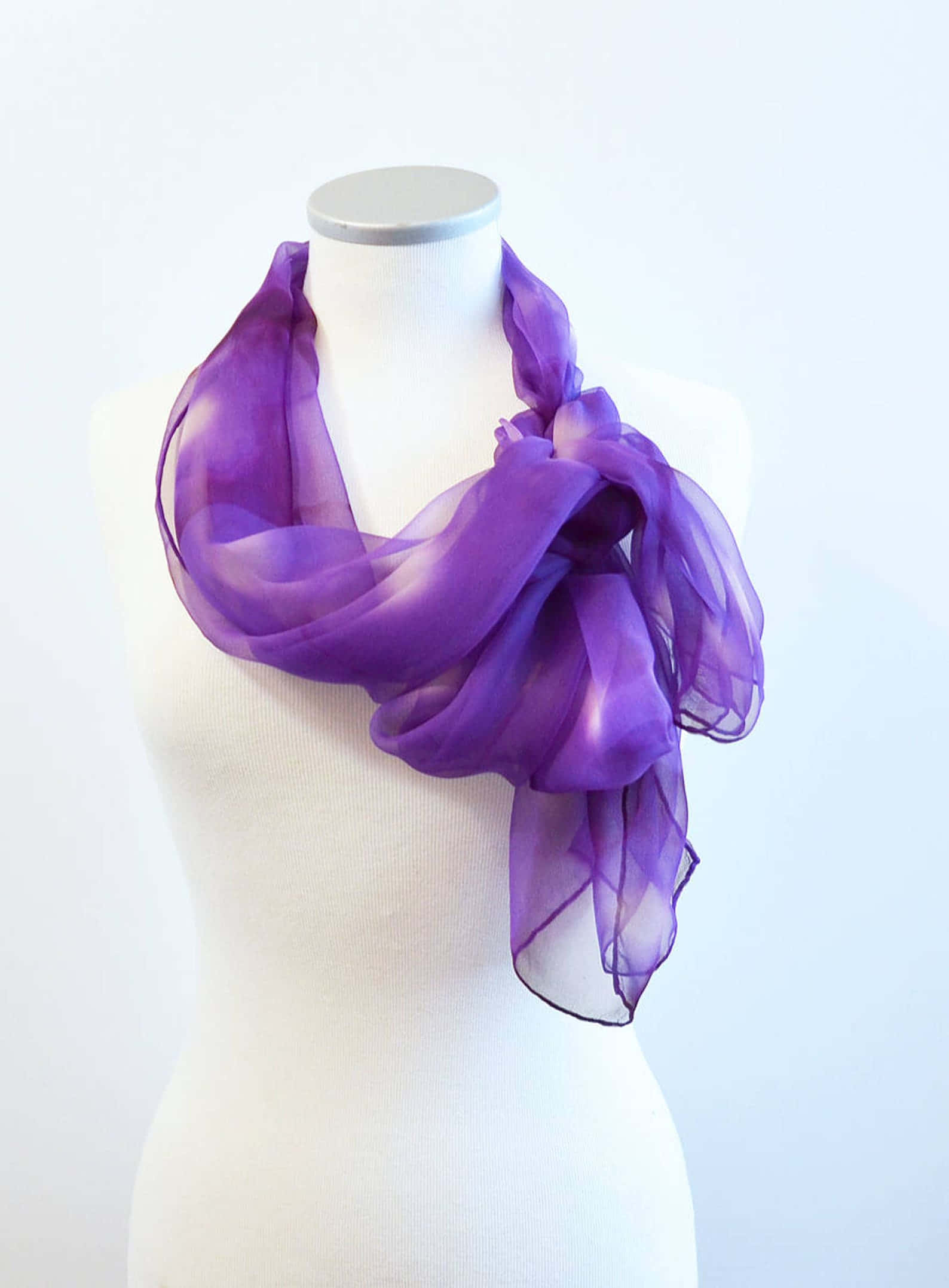 Purple Scarf 桌布 壁紙 — 一條飄逸的紫色雪紡圍巾，優雅地披在白色人體模型頸部，背景為潔淨的白色。
