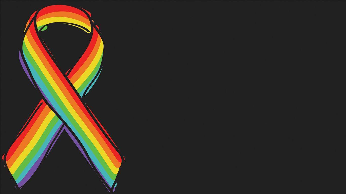 彩虹 桌布 壁紙 — 一條鮮豔的彩虹絲帶象徵LGBTQ+驕傲，在純黑背景上格外突出。