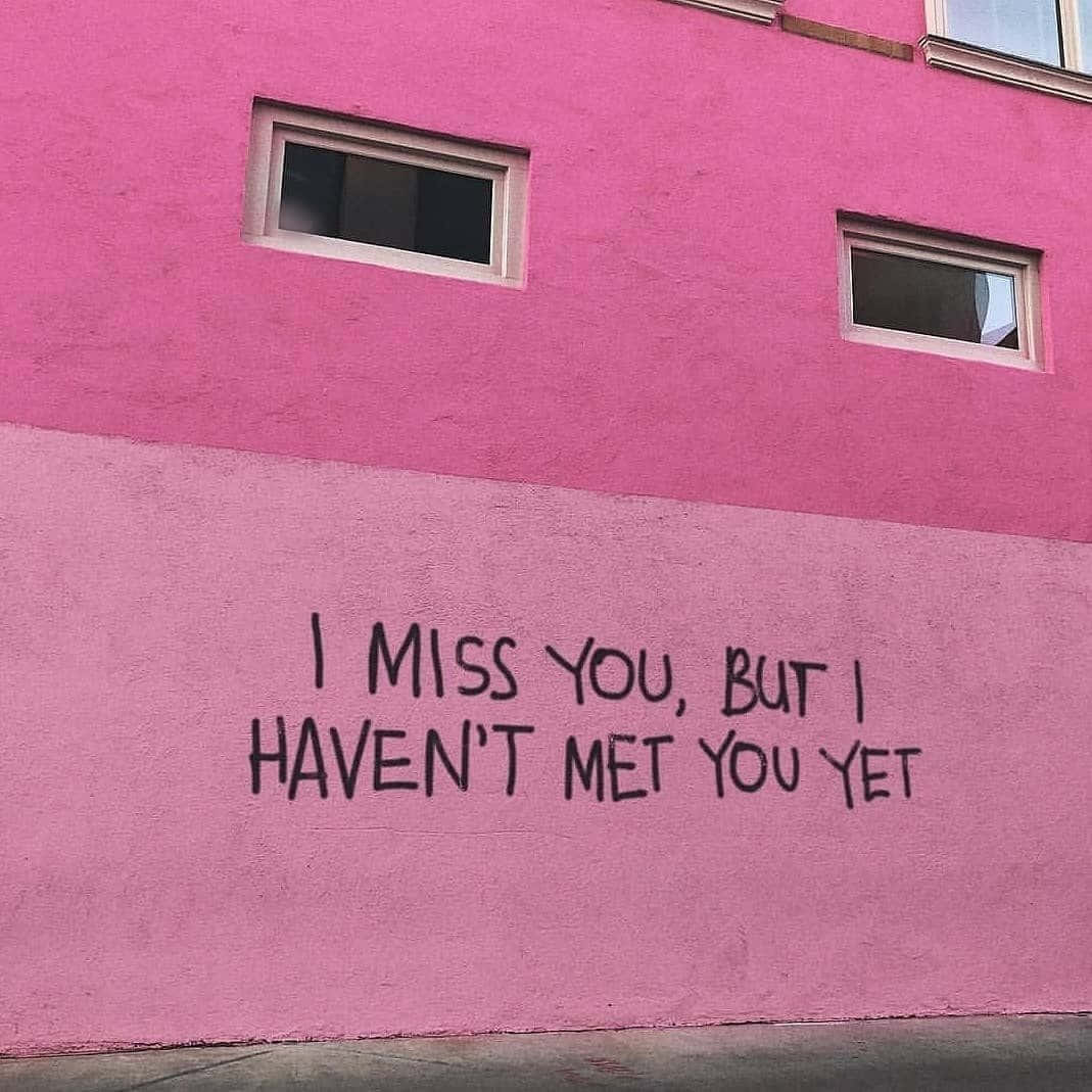 I Miss You 桌布 壁紙 — 一棟充滿活力的粉紅色建築牆上，在兩扇小窗戶下方有粗體黑色塗鴉文字寫著「I MISS YOU BUT I HAVEN'T MET YOU YET」。