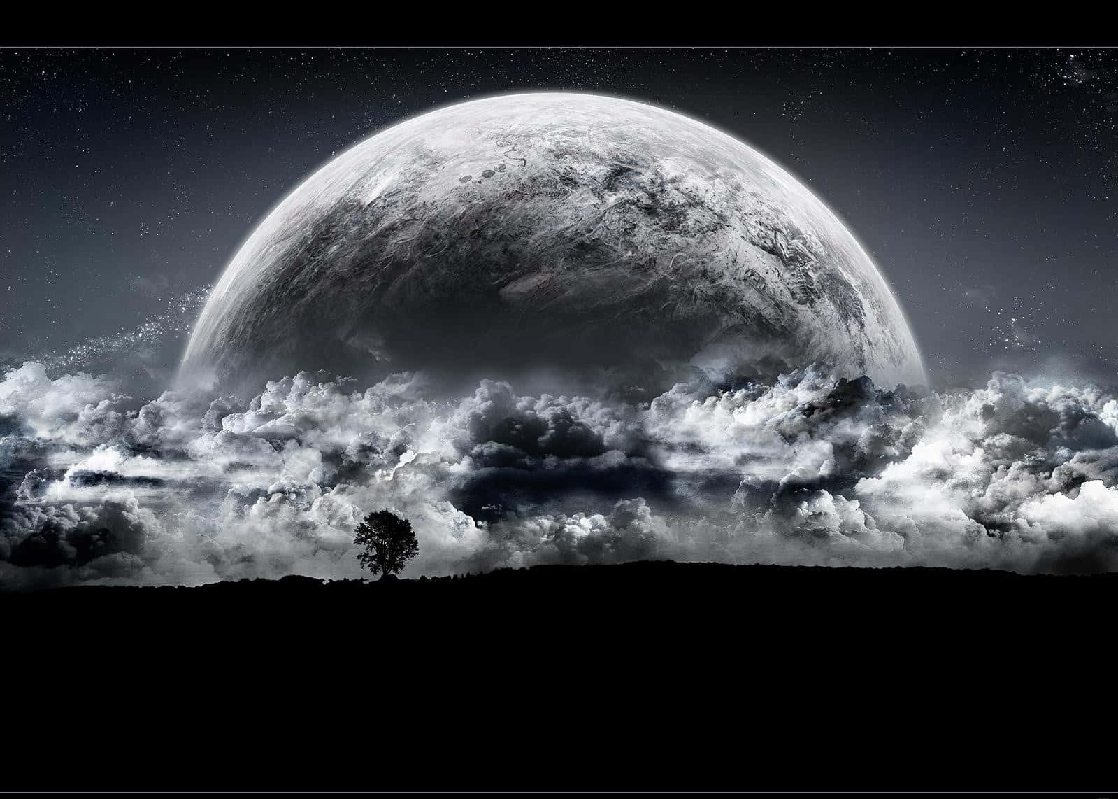 Dark Moon 桌布 壁紙 — 一棵孤獨的樹影矗立在黑暗的山丘上，下方是一顆巨大的行星穿過戲劇性的雲層在繁星點點的夜空中升起。