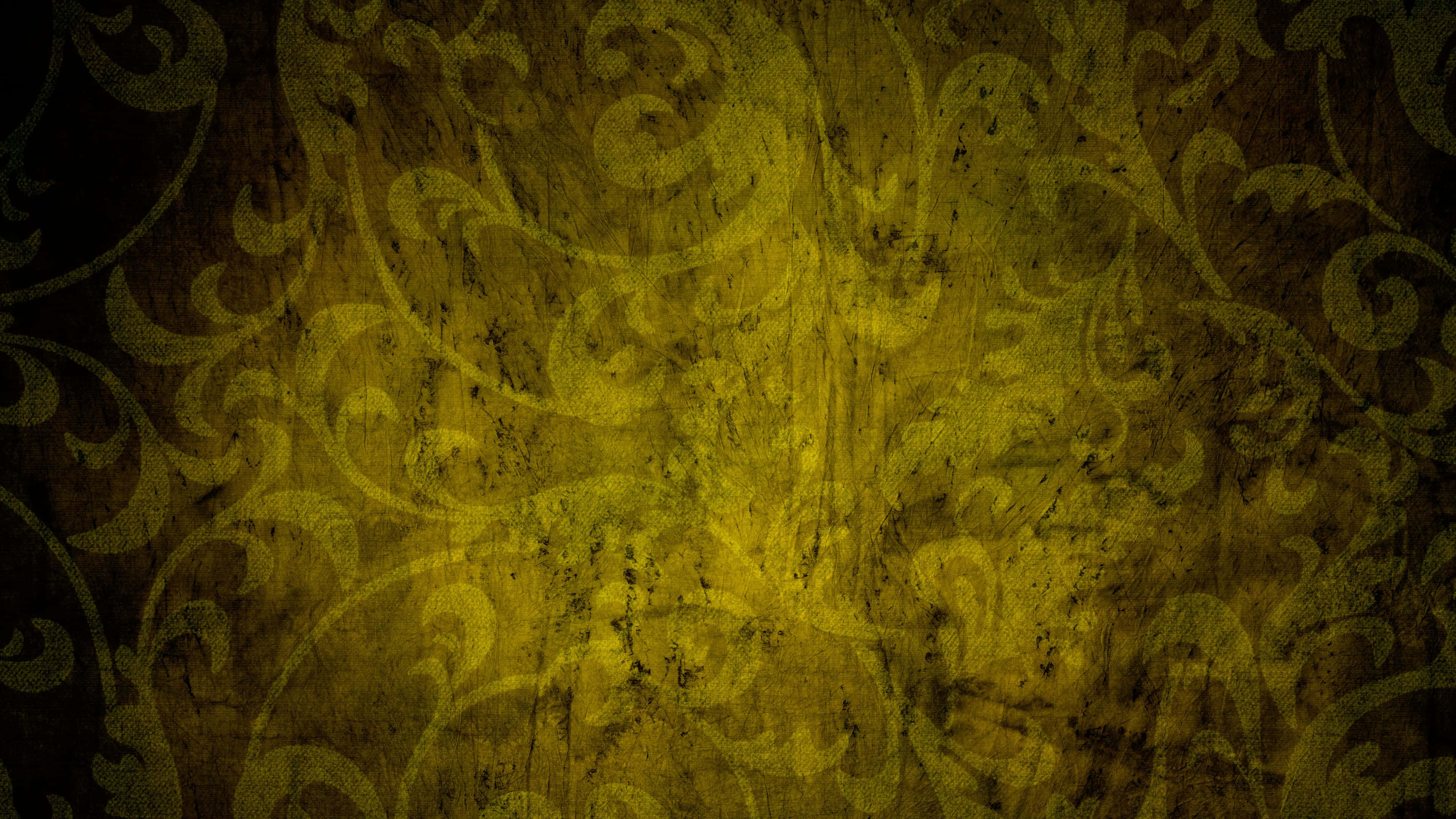 Yellow Grunge 桌布 壁紙 — 一款帶有紋理的牆紙，在深棕色頹廢背景上呈現旋轉的金黃色大馬士革圖案。