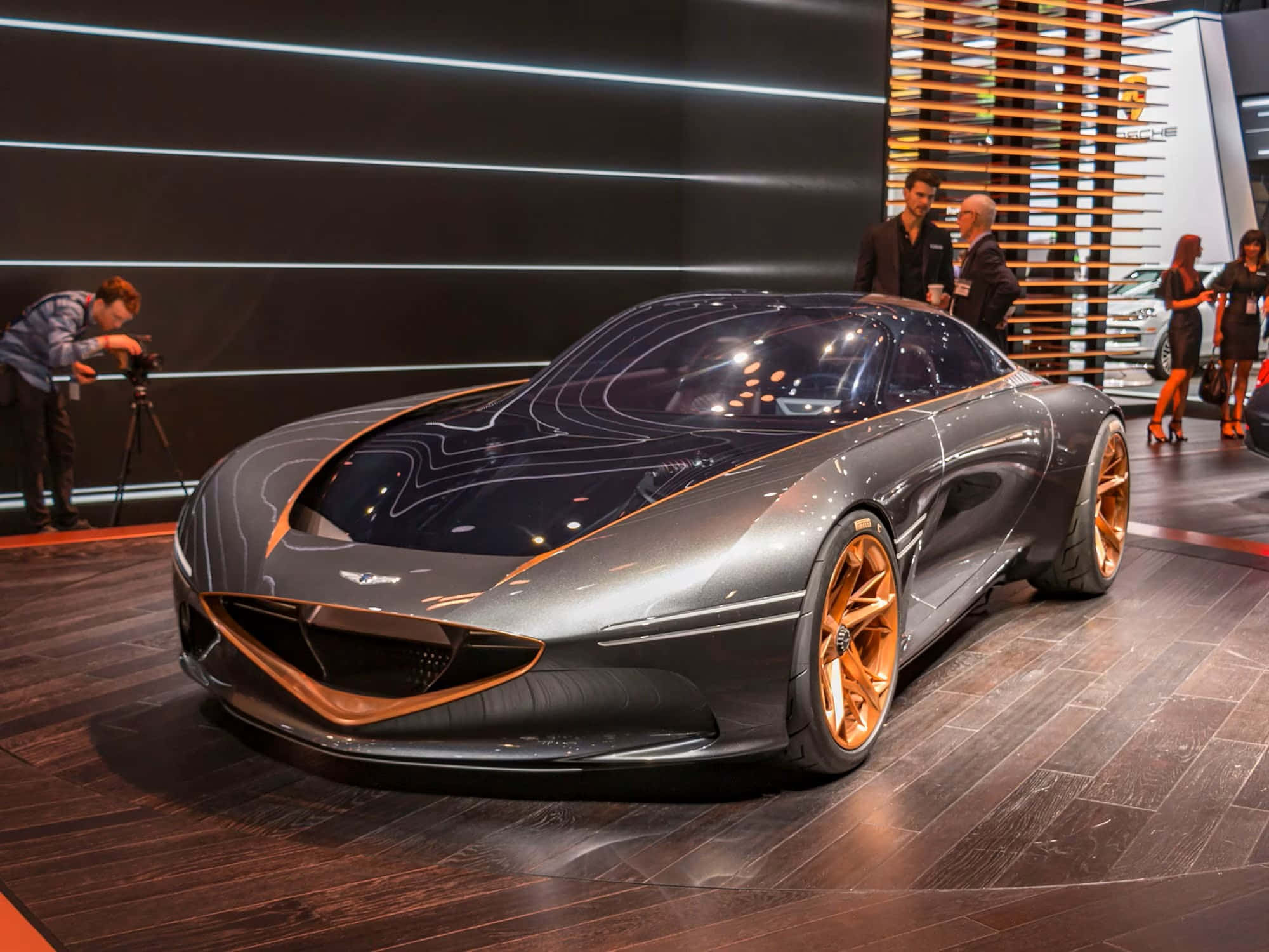 Genesis Essentia 桌布 壁紙 — 一款時尚未來感跑車配金色點綴，在車展的明亮燈光下閃耀。