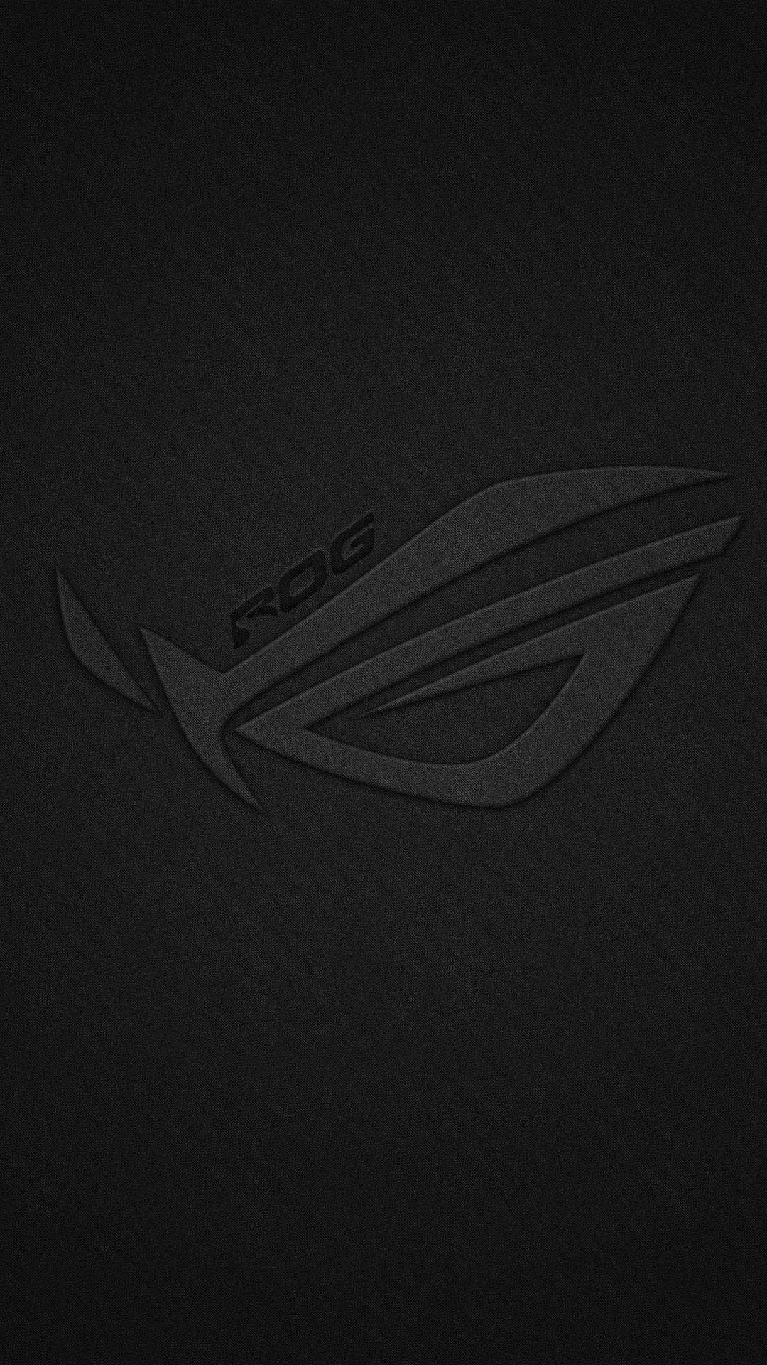 ASUS ROG 桌布 壁紙 — 一款極簡黑色桌布，ROG 標誌低調壓印在帶有紋理的深色表面上。