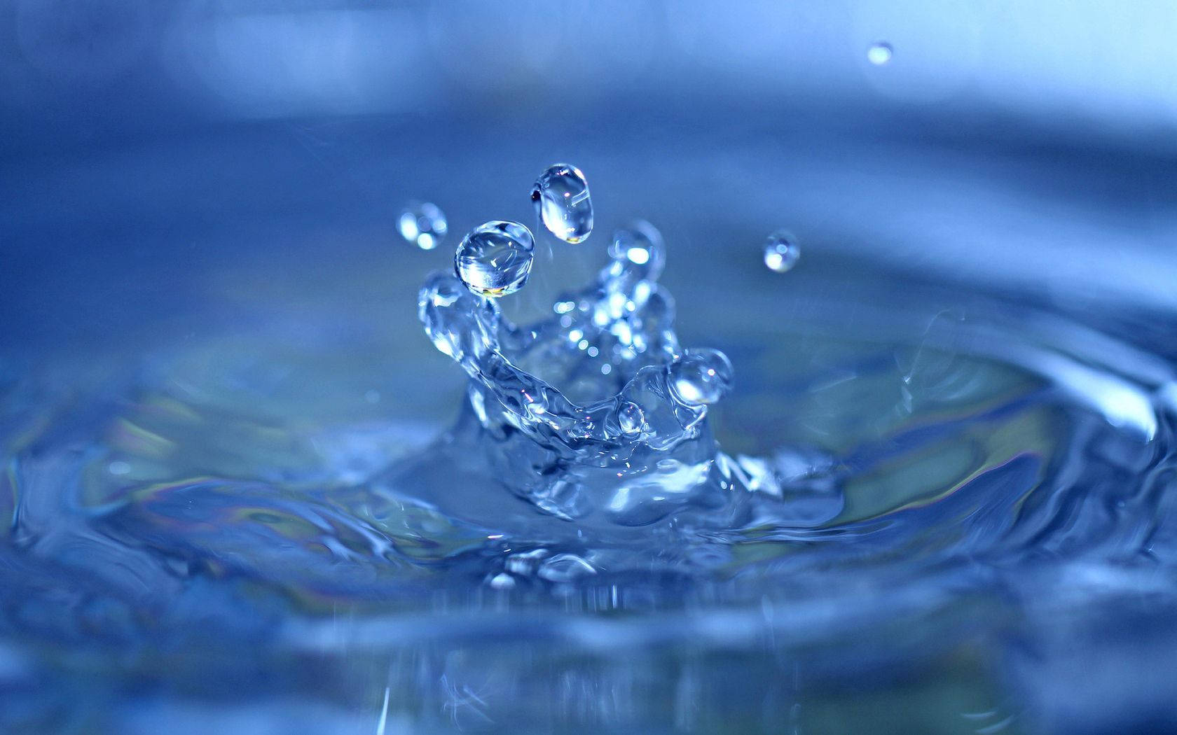 水滴冠在藍色水面上飛濺。