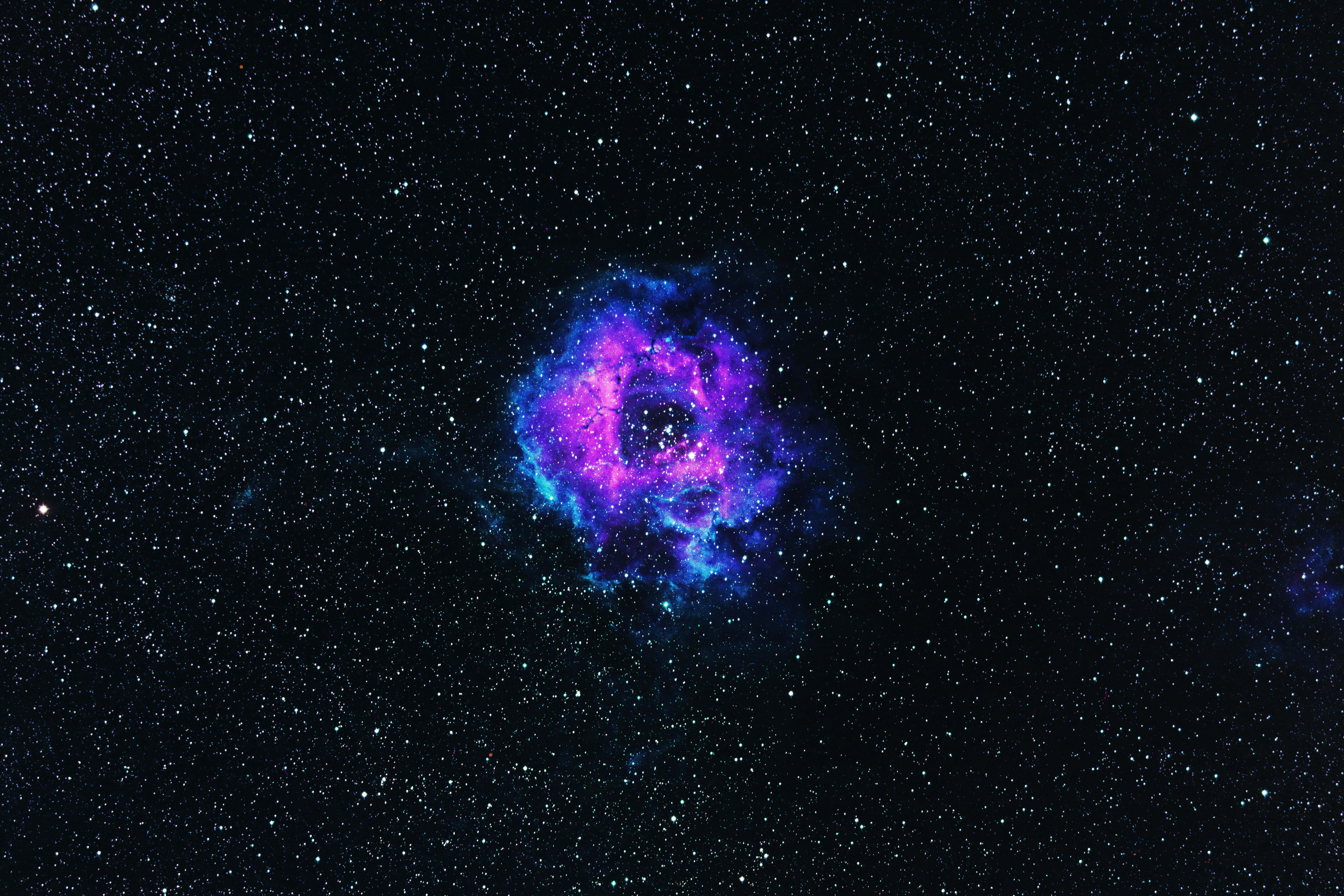 Twitter Header 桌布 壁紙 — 一片充滿活力的紫色和藍色星雲在深空的星場中發光。