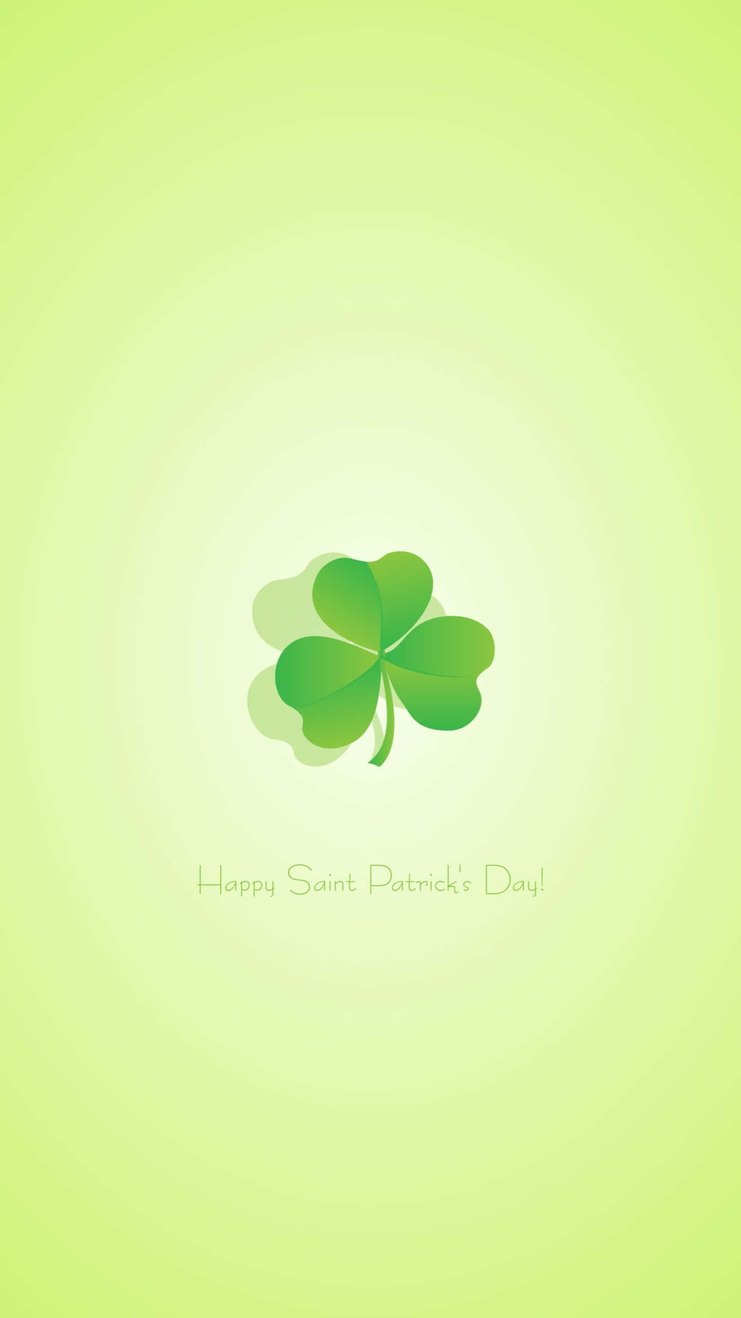Saint Patricks Day 桌布 壁紙 — 一片充滿活力的綠色四葉草居中於柔和漸變背景上，下方有節日聖帕特里克節祝福語。