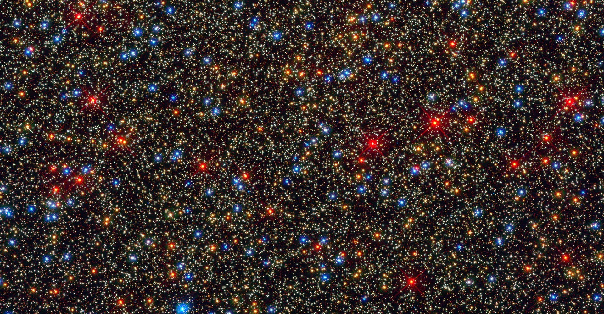 Star Cluster 桌布 壁紙 — 一片密集的星場，在黑色宇宙虛空中閃耀著紅、藍、金色光芒。