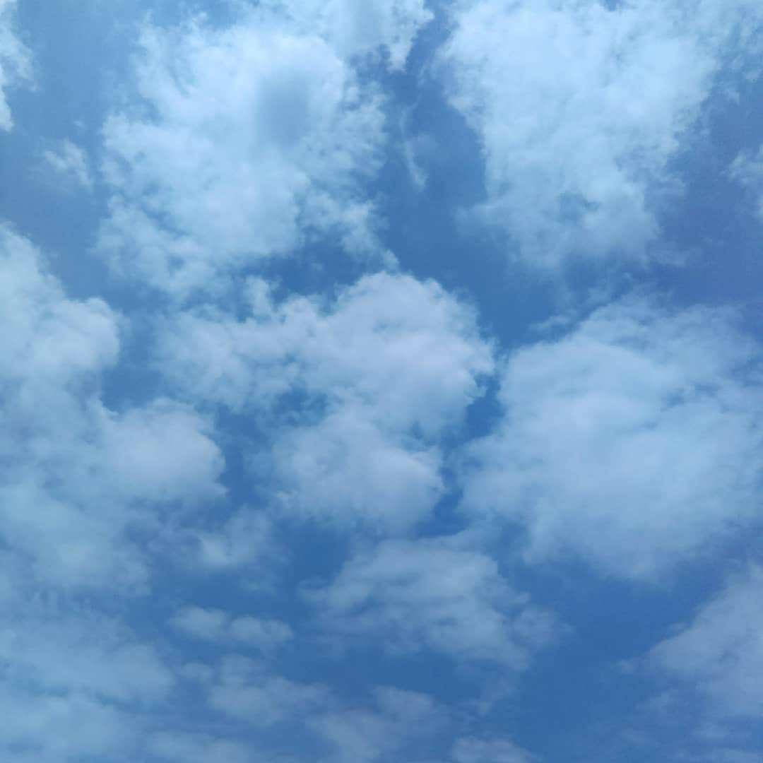 雲朵 桌布 壁紙 — 一片寧靜的天空，柔軟的白雲在充滿活力的藍色畫布上飄移。