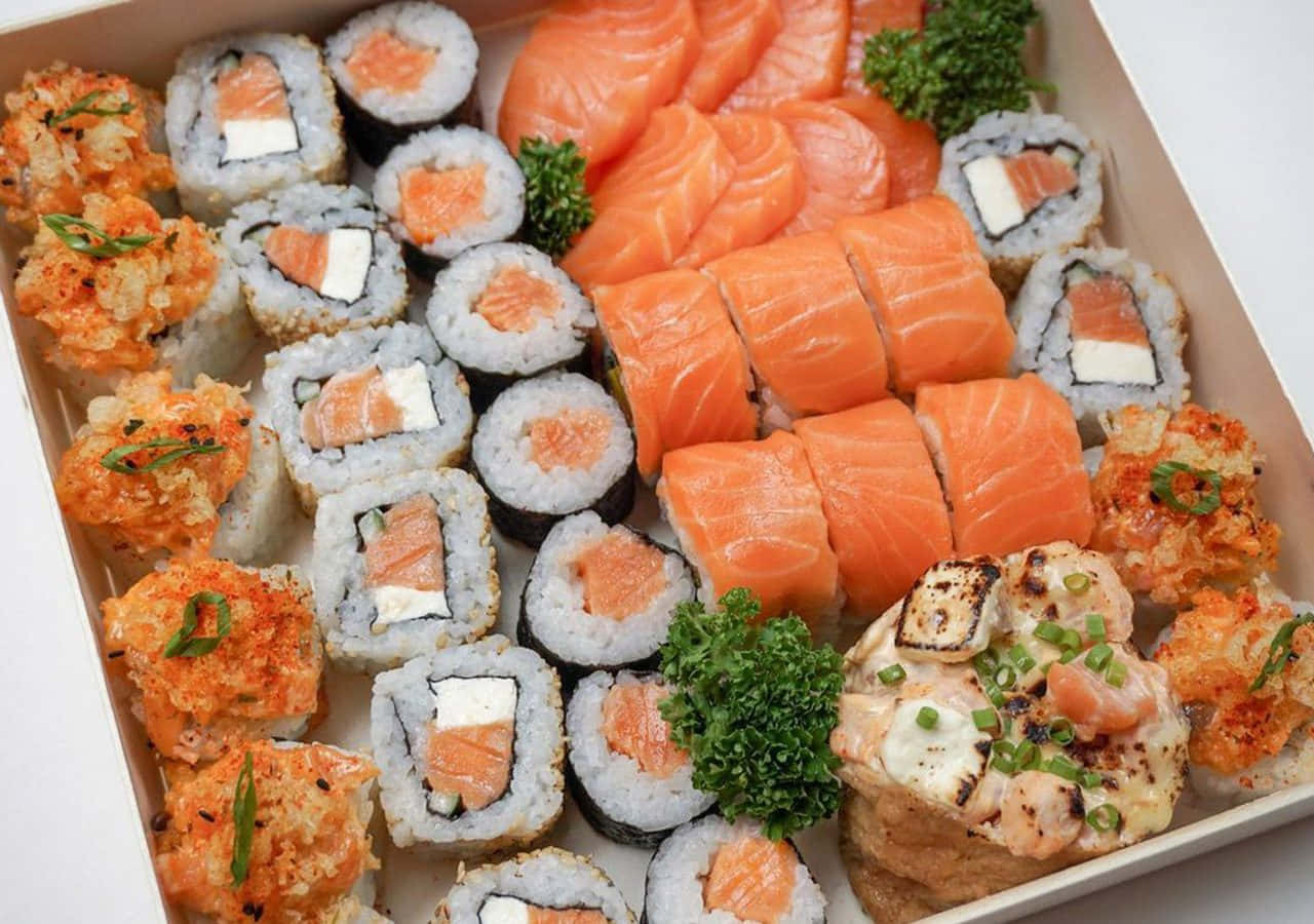 Salmon 桌布 壁紙 — 一盒色彩繽紛的雜錦壽司，包括三文魚刺身卷、天婦羅卷和燒卷，並以歐芹裝飾。