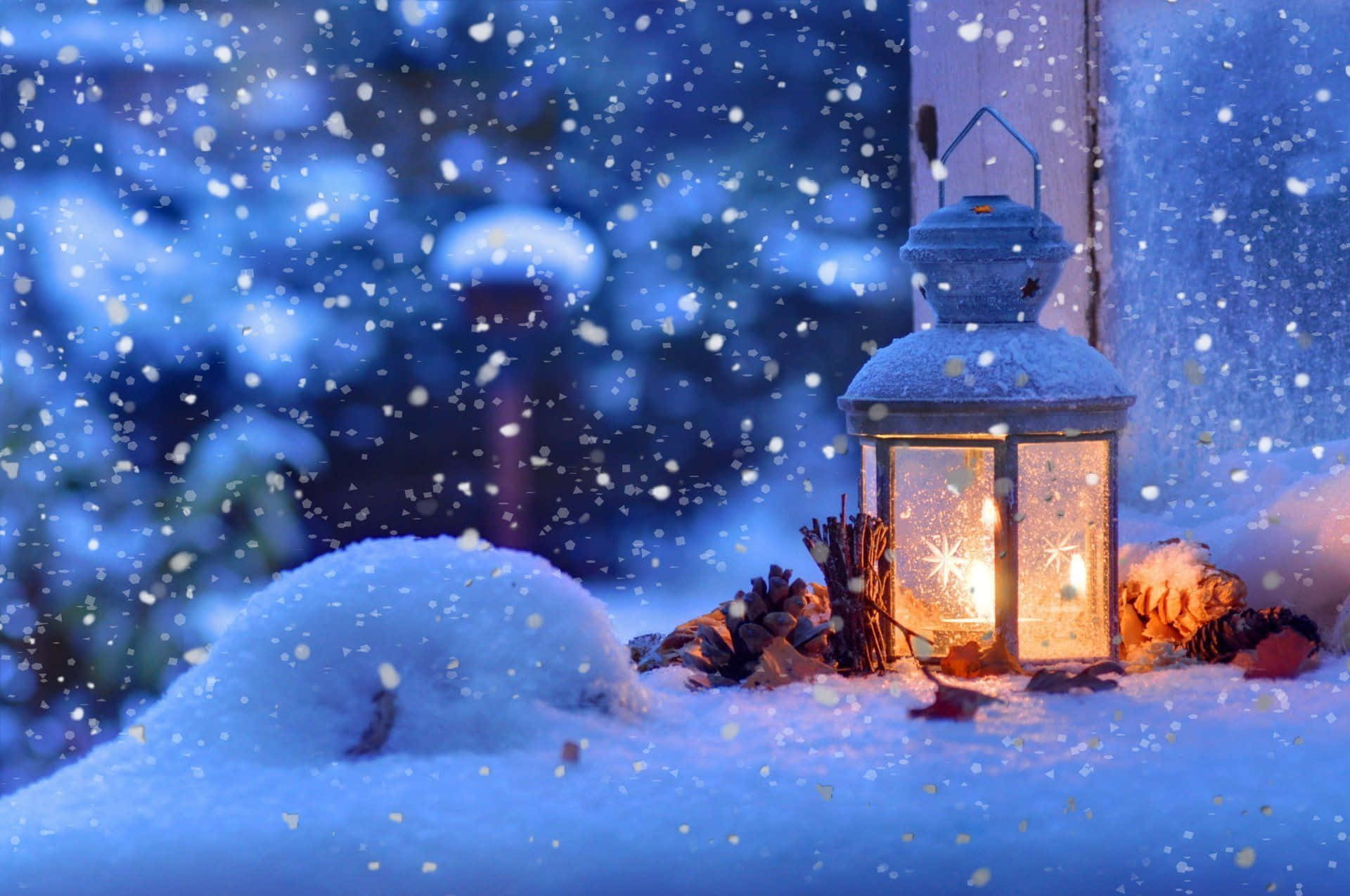 Winter Christmas 桌布 壁紙 — 一盞發光的燈籠在雪地上投射出溫暖的光芒，雪花在模糊的冬夜背景下飄落。