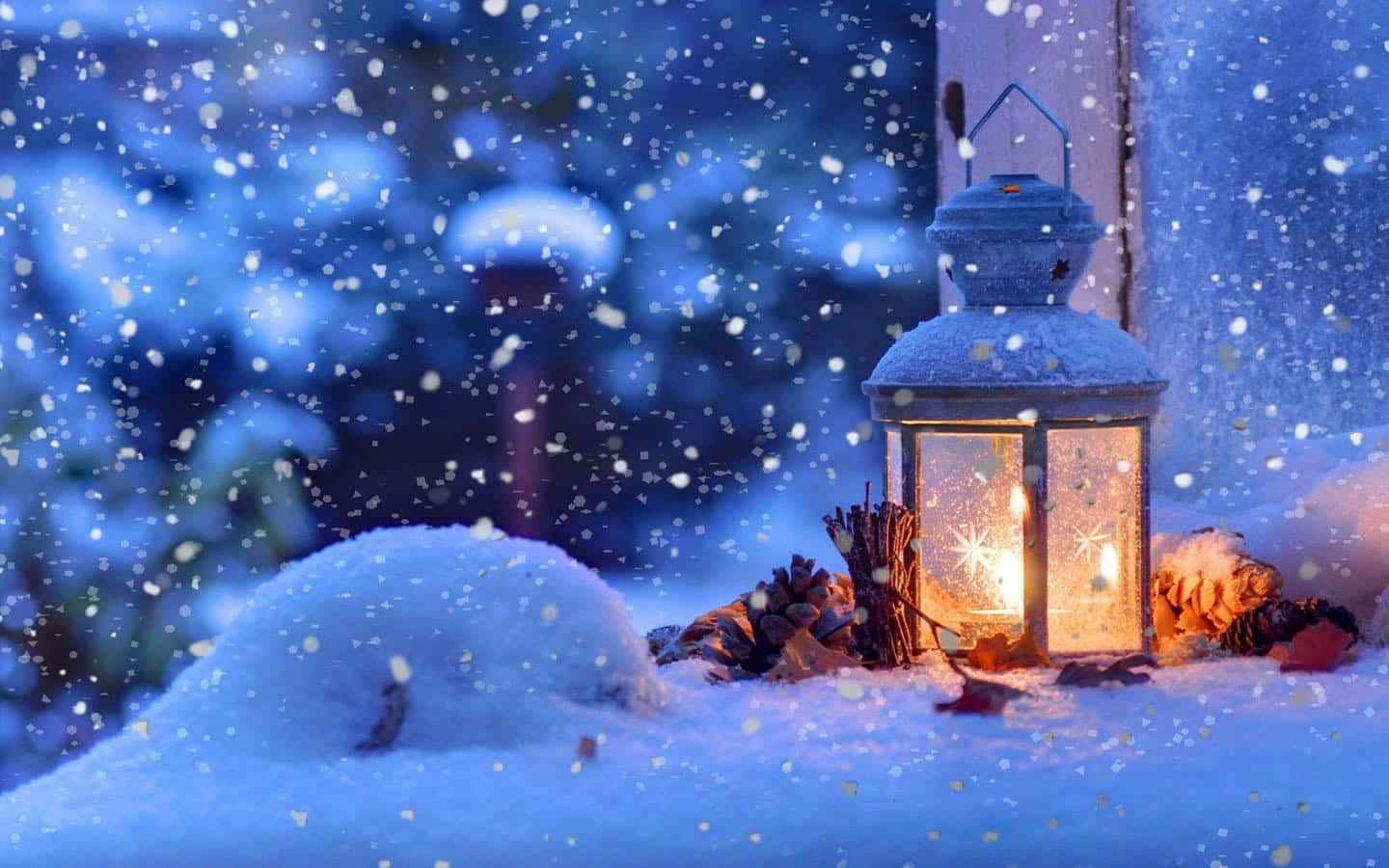Snowstorm 桌布 壁紙 — 一盞發光的燈籠在雪地上投射出溫暖的光芒，雪花在模糊的冬季背景下飄落。