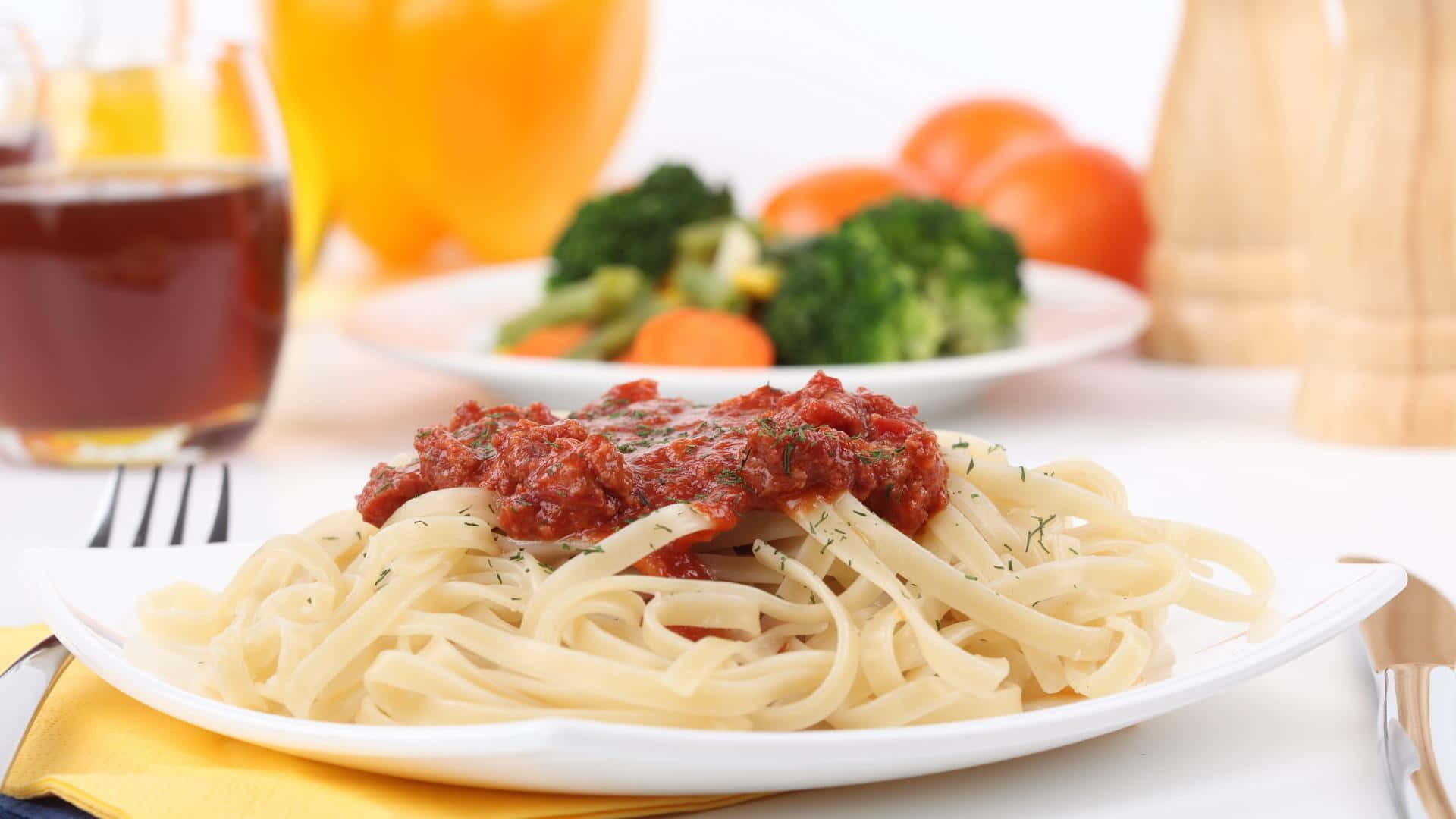 Pasta 桌布 壁紙 — 一盤奶油寬麵條配上濃郁的番茄醬和新鮮香草，搭配蒸西蘭花和胡蘿蔔，準備好享用。