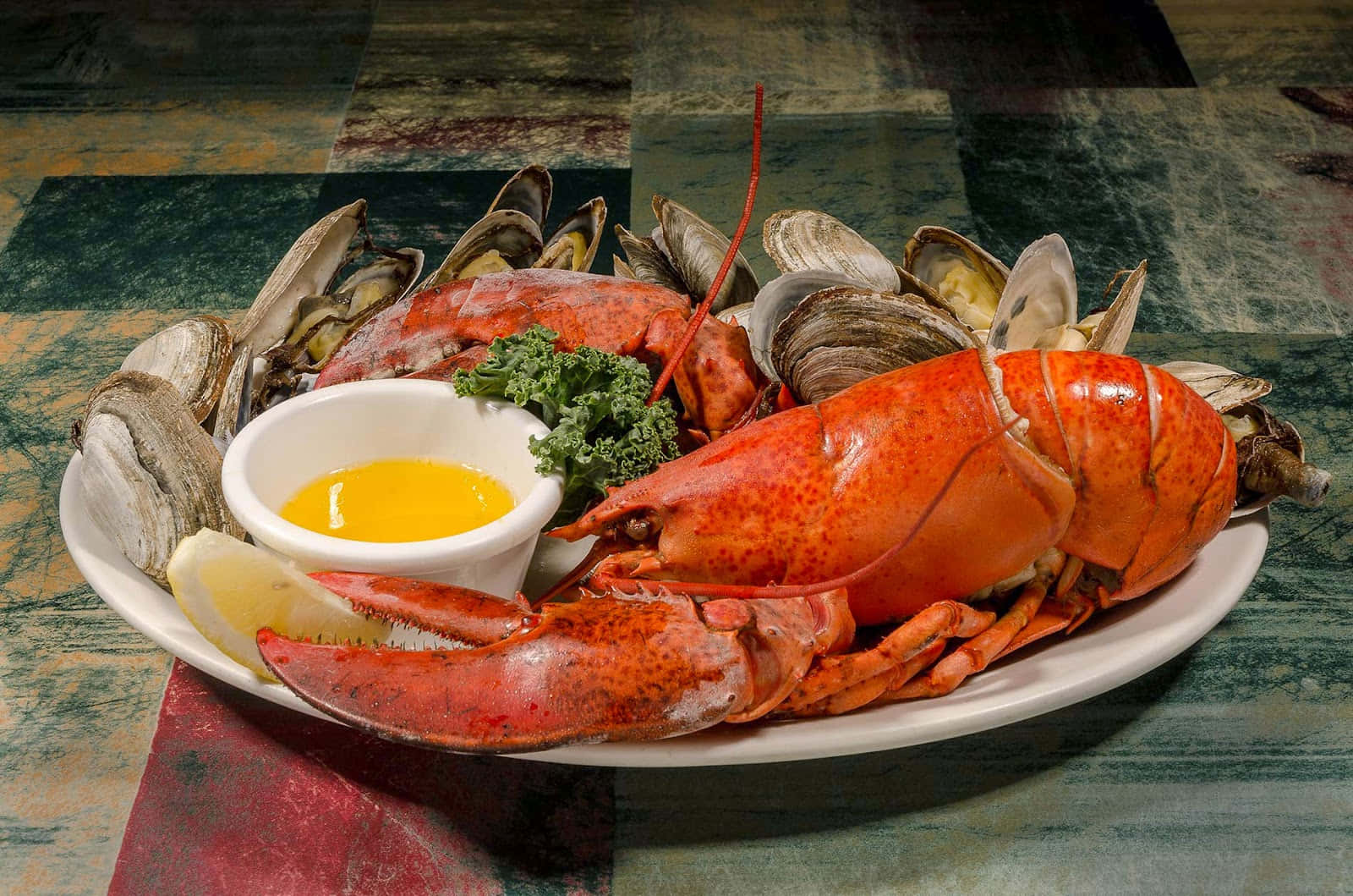 Seafood 桌布 壁紙 — 一盤色彩鮮豔的蒸龍蝦和青口，配以歐芹和檸檬裝飾，旁邊放著一碗融化牛油。