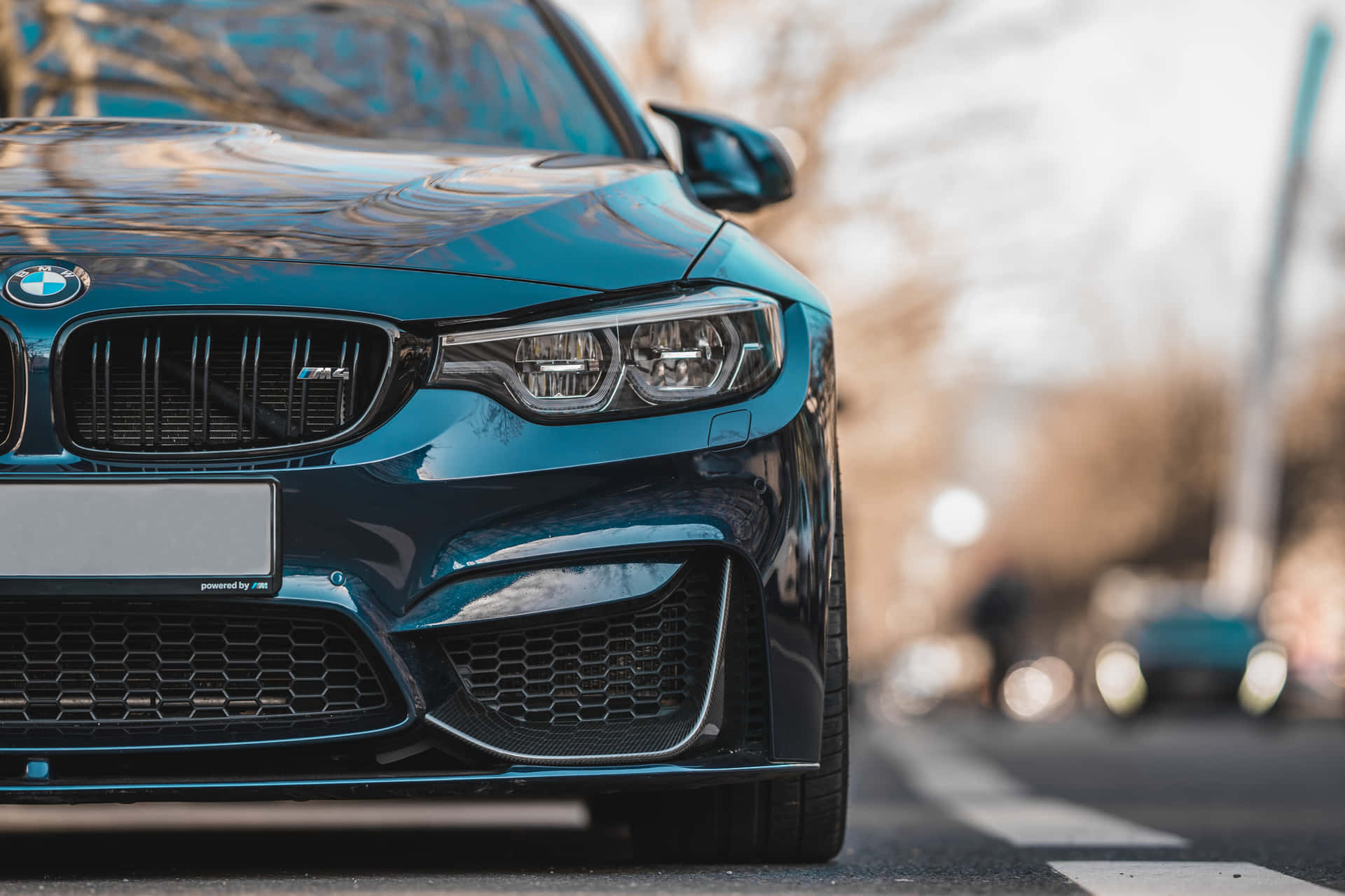 青綠色BMW M3跑車停泊在街道上，背景模糊。