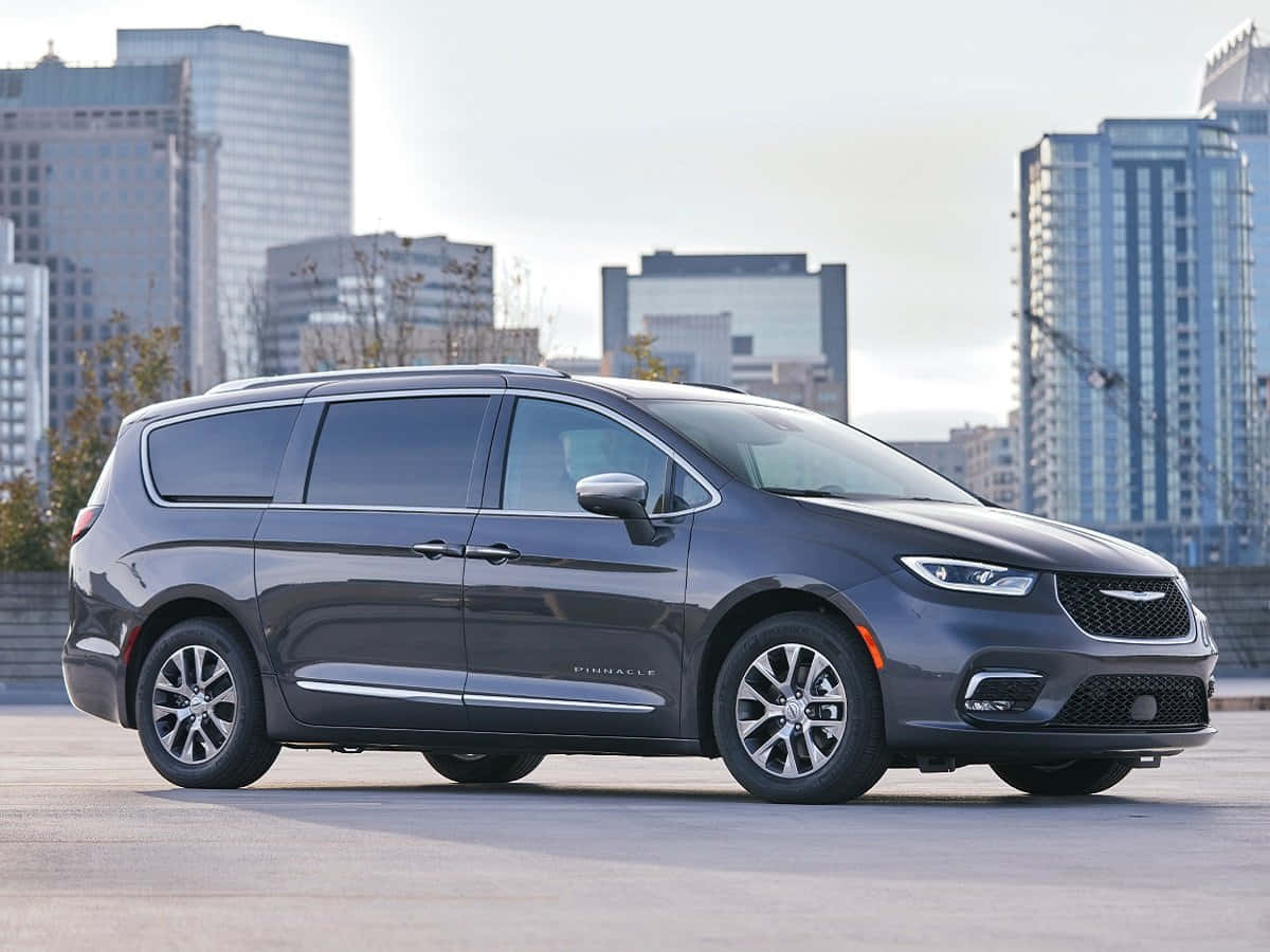 一睹真正奢華的 Chrysler 車款 壁紙 — 一架時尚灰色嘅Chrysler Pacifica小型貨車停泊喺城市天台，背景係現代摩天大廈。