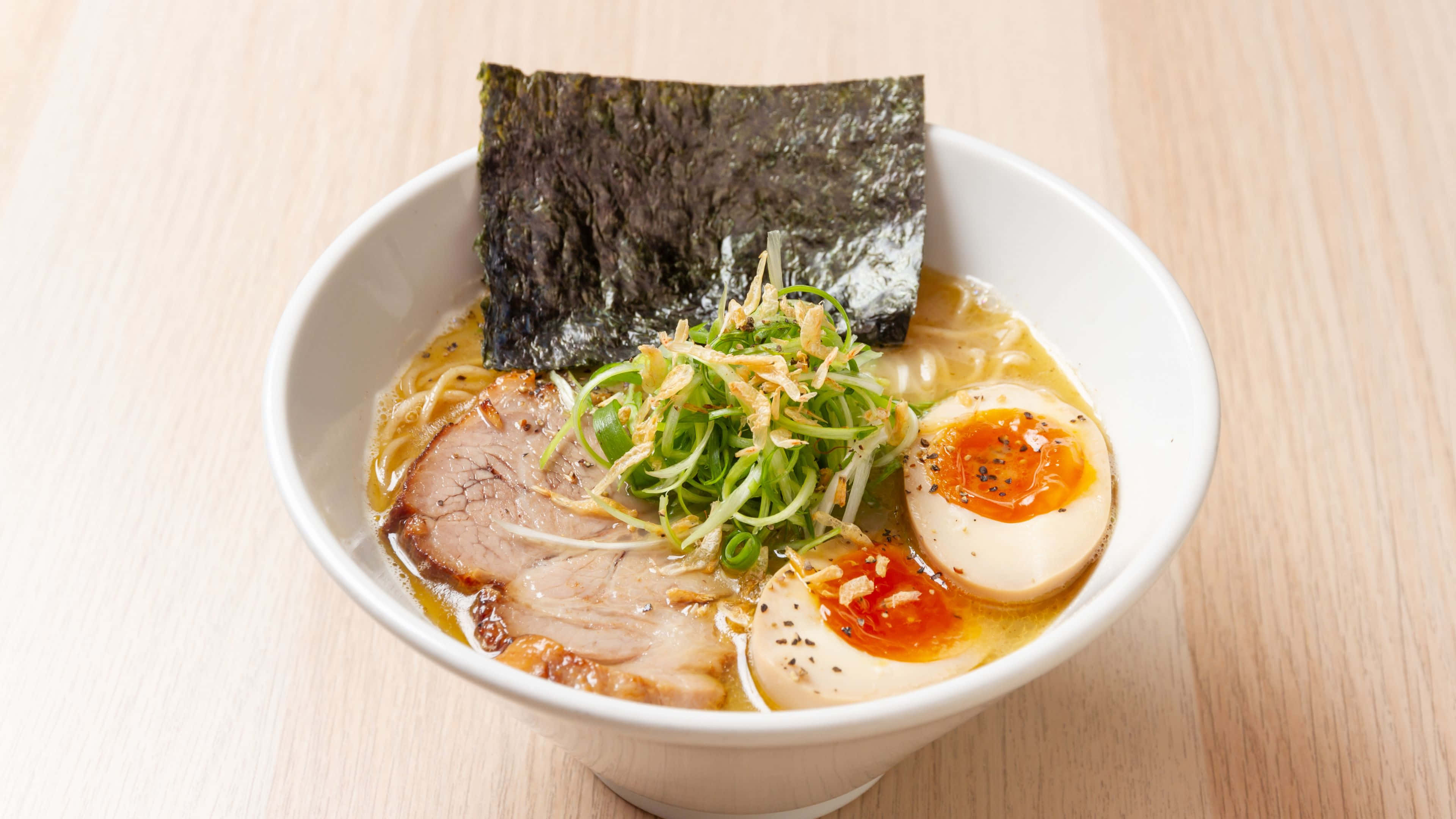 Noodles 桌布 壁紙 — 一碗冒煙嘅拉麵，有溏心蛋、紫菜同叉燒，放喺淺色木枱上。