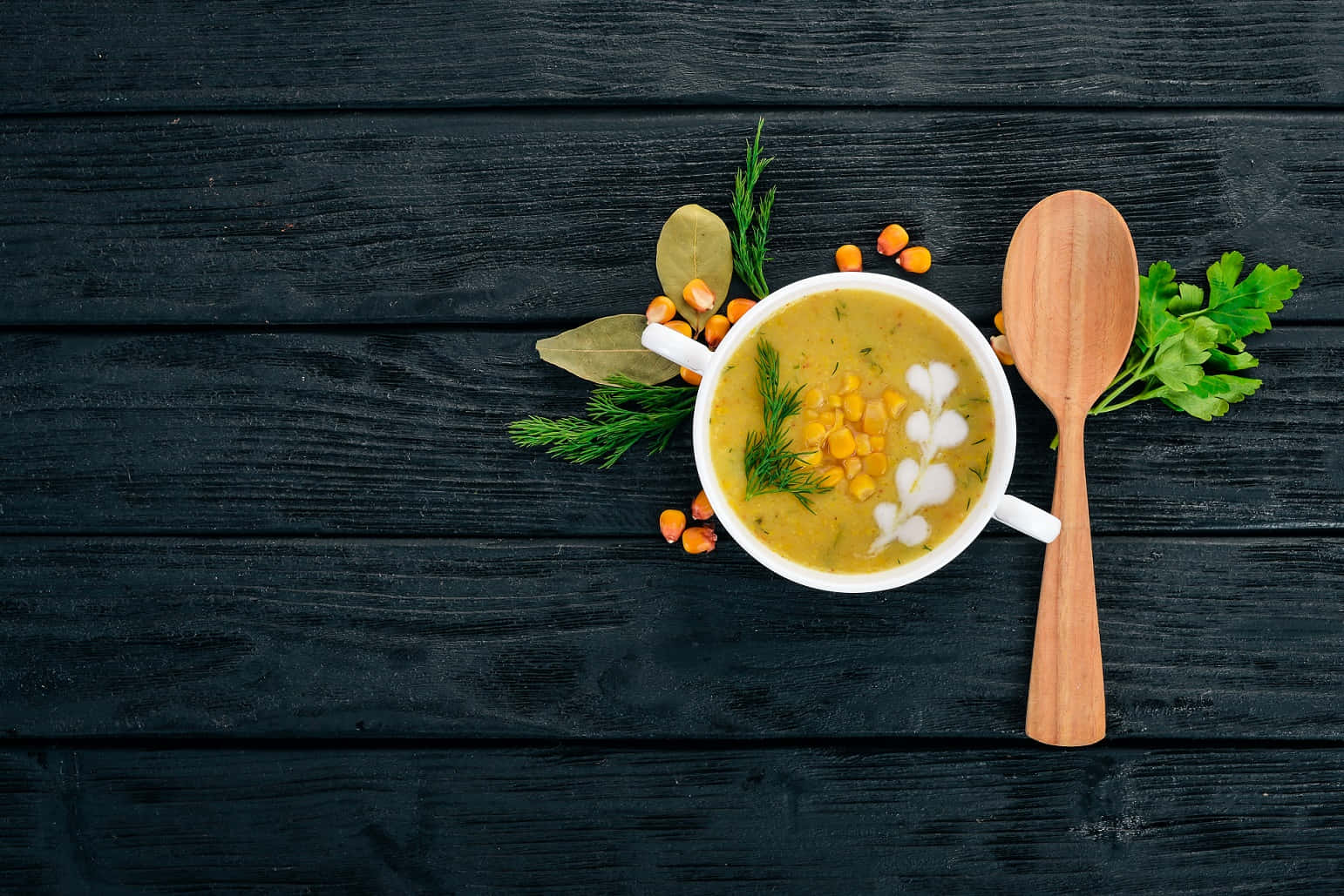Soup 桌布 壁紙 — 一碗冒煙的奶油玉米湯，飾以香草和奶油藝術，旁邊放著一把木勺，放在深色鄉村木桌上。