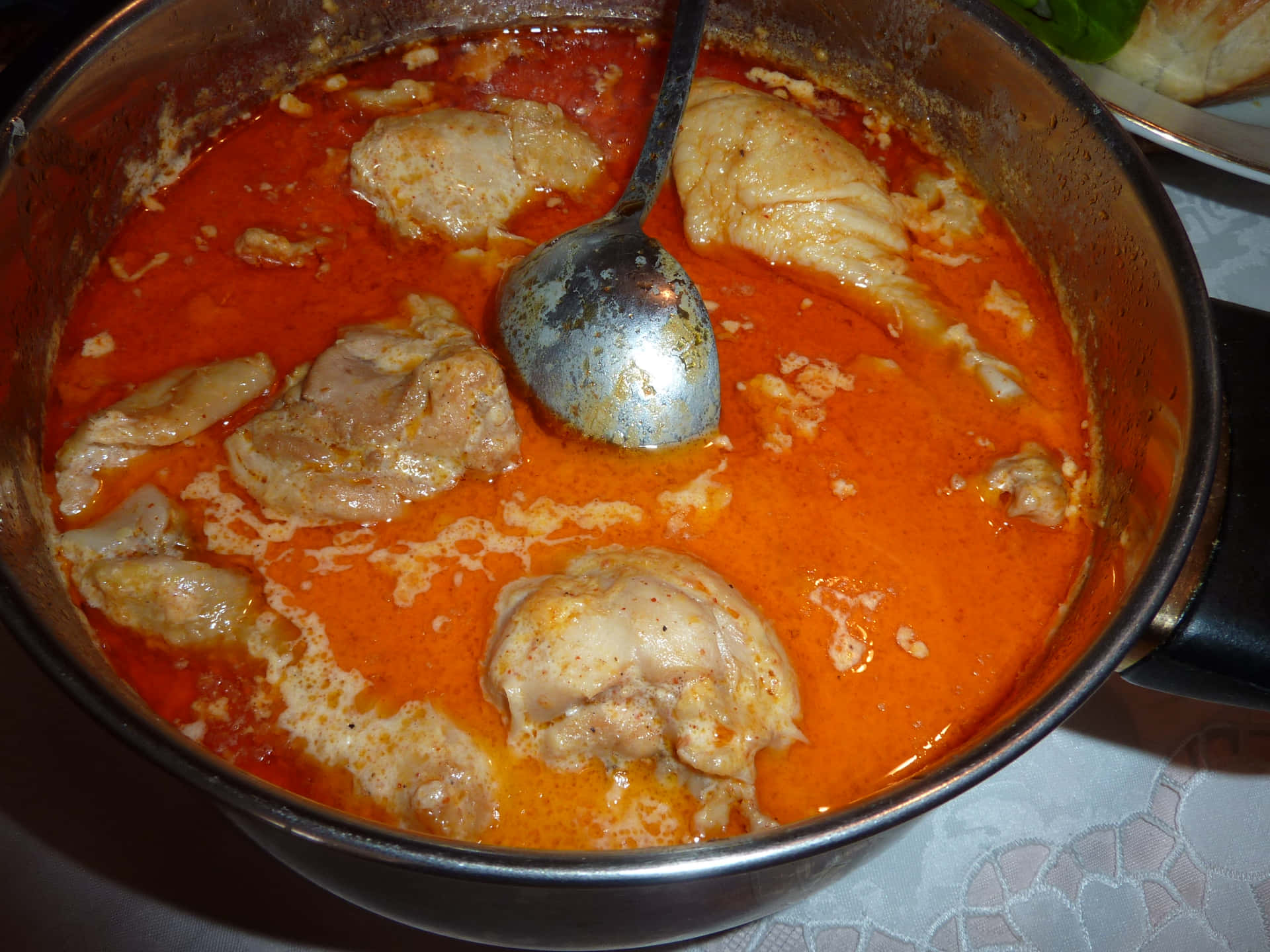 一鍋橙色雞肉咖喱，裡面有湯匙。 — 美食 壁紙