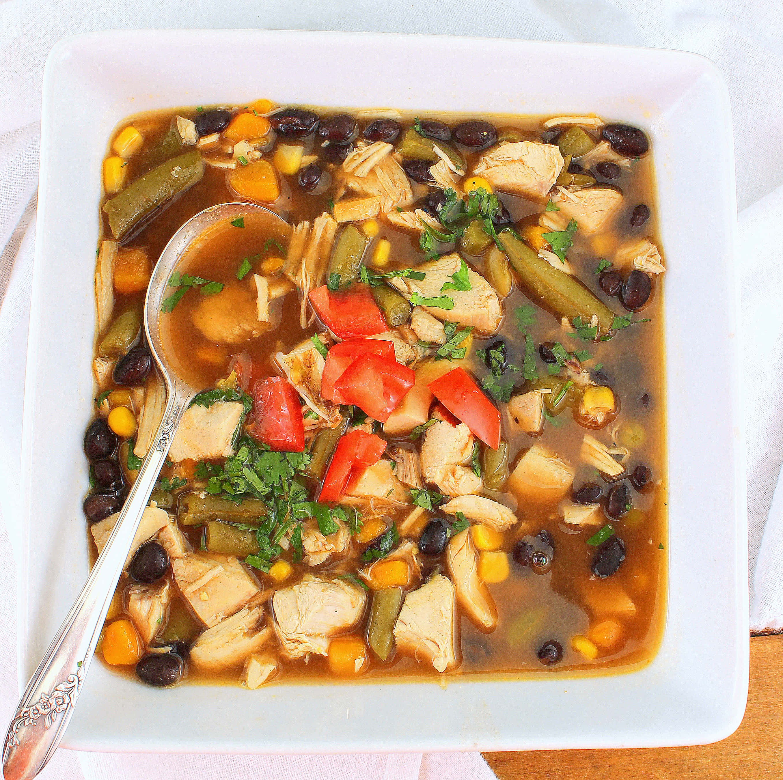 Black Bean Soup 桌布 壁紙 — 一碗熱騰騰的豐盛雞肉玉米餅湯，配上黑豆、玉米和新鮮芫荽裝飾。