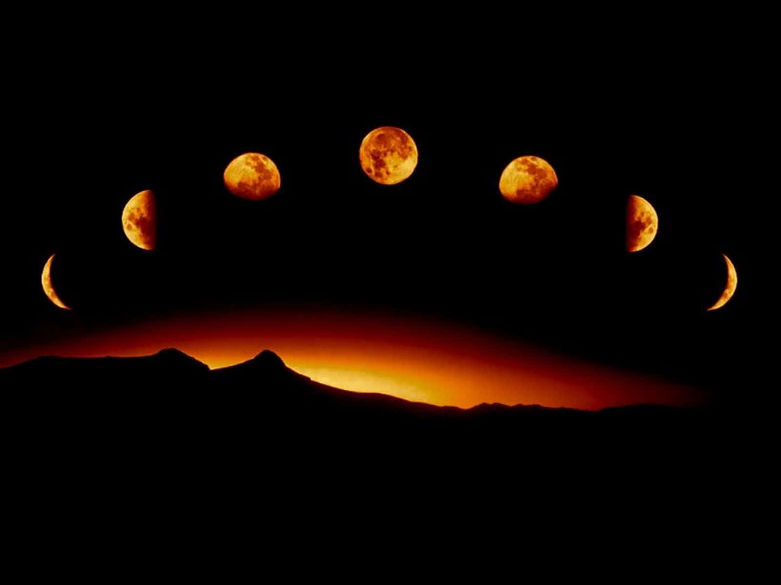 Moon Phases 桌布 壁紙 — 一系列戲劇性的月相在琥珀色中發光，位於暮色中輪廓分明的山脈之上。