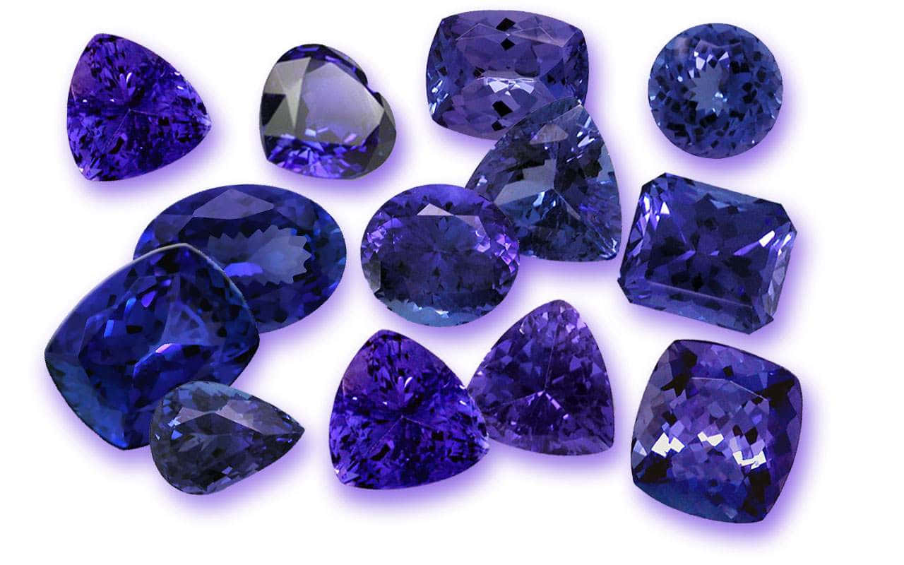 Gemstone 桌布 壁紙 — 一系列深藍色坦桑石寶石以不同切割方式閃耀在純白背景上。