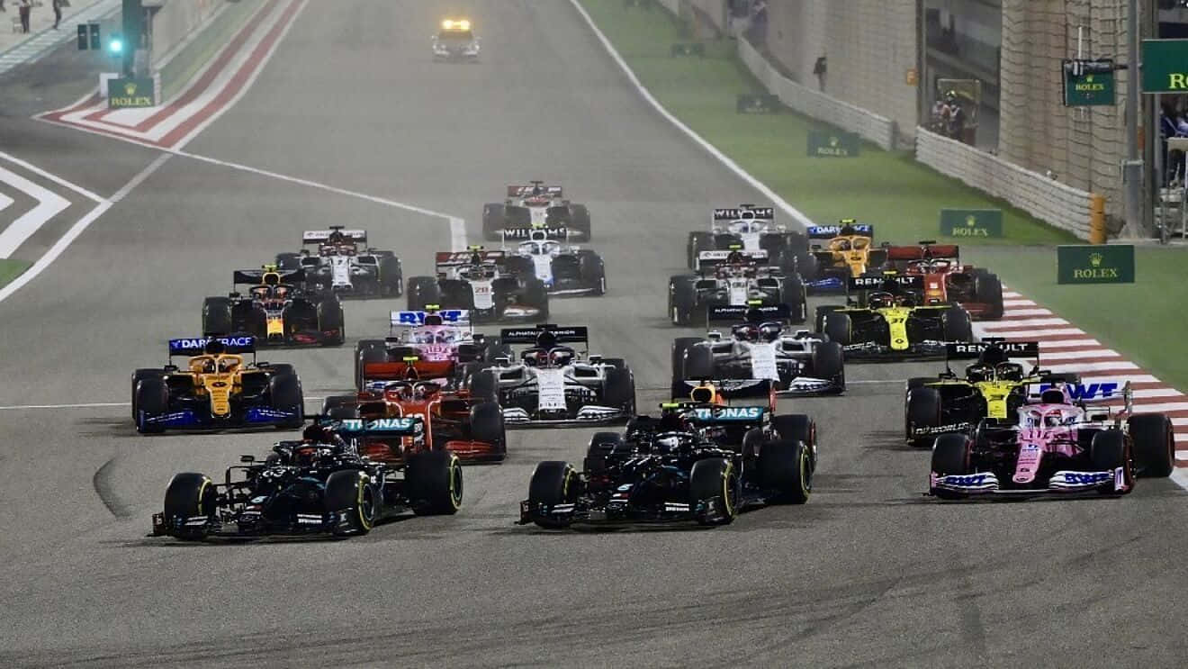 一級方程式大獎賽賽車競速 壁紙 — F1 賽車在夜間濕滑的賽道上咆哮，明亮的車頭燈劃破迷霧。