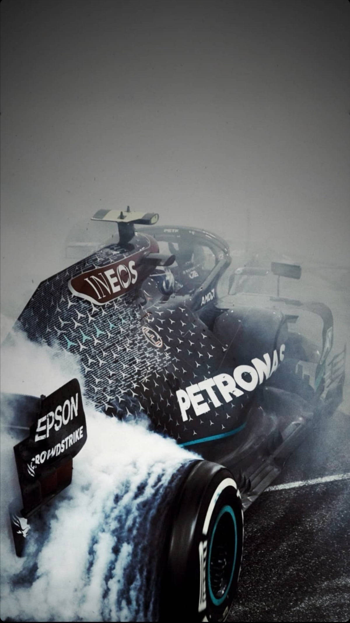 一級方程式賽車 iPhone 壁紙 — 一輛帶有Petronas和Epson標誌的黑色一級方程式賽車在潮濕的賽道上側滑，激起白色水花。
