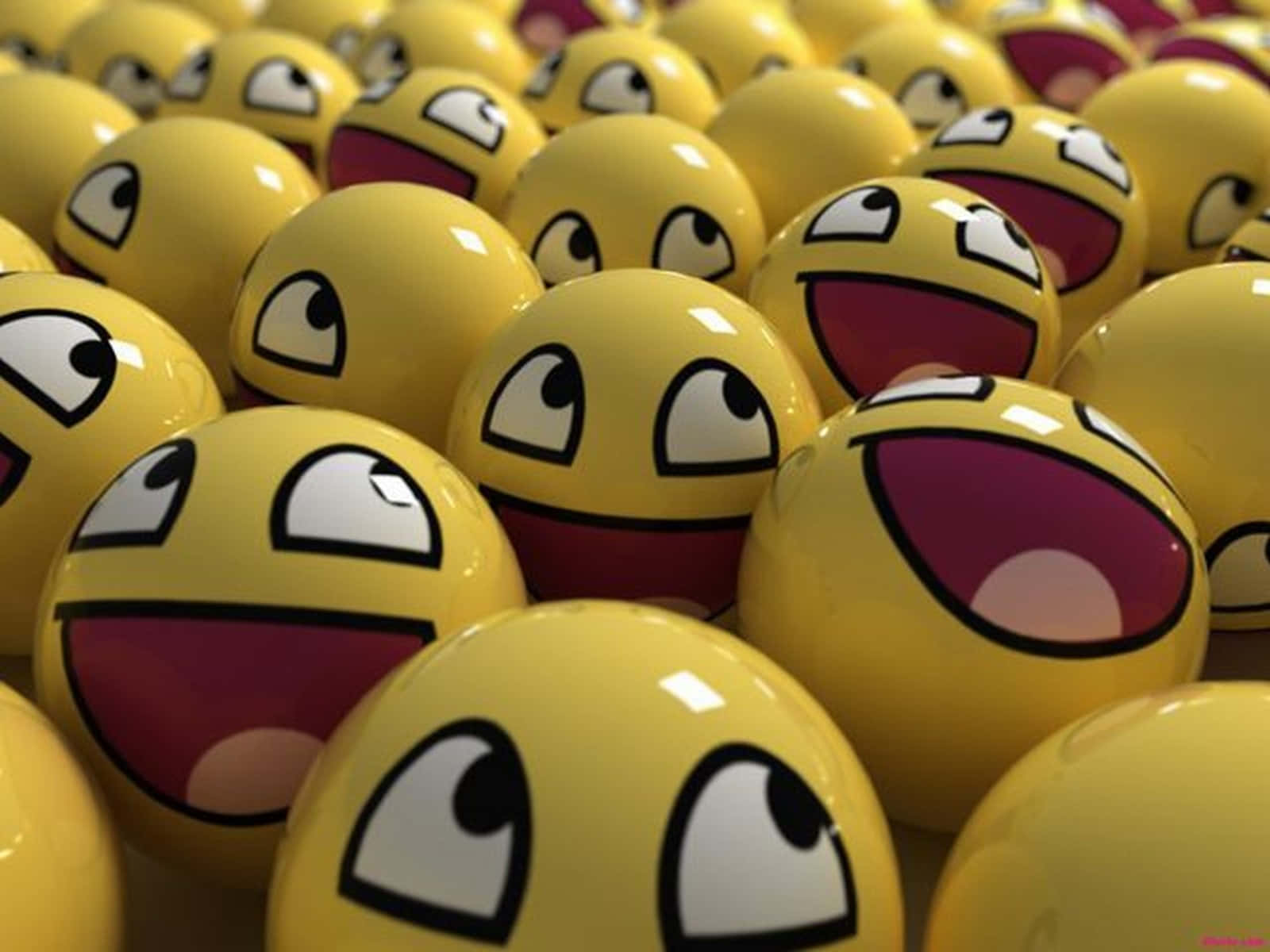 Smiley 桌布 壁紙 — 一組密集的光澤黃色表情符號球，帶有咧嘴大笑的臉和凸出的眼睛。