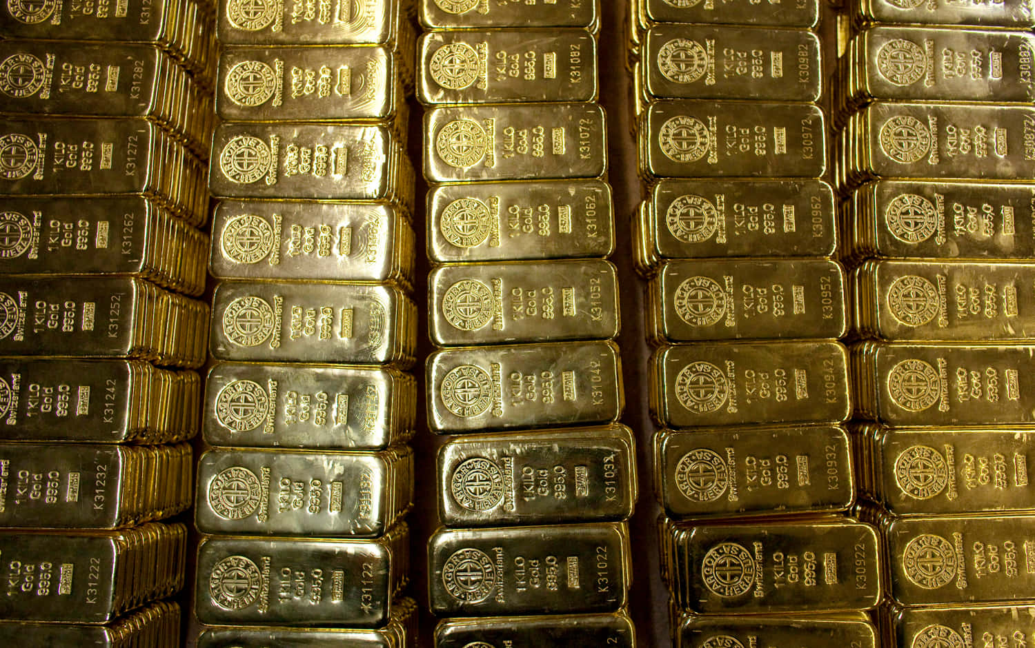 在帶有反射表面的保險庫中堆疊的雕刻金條。