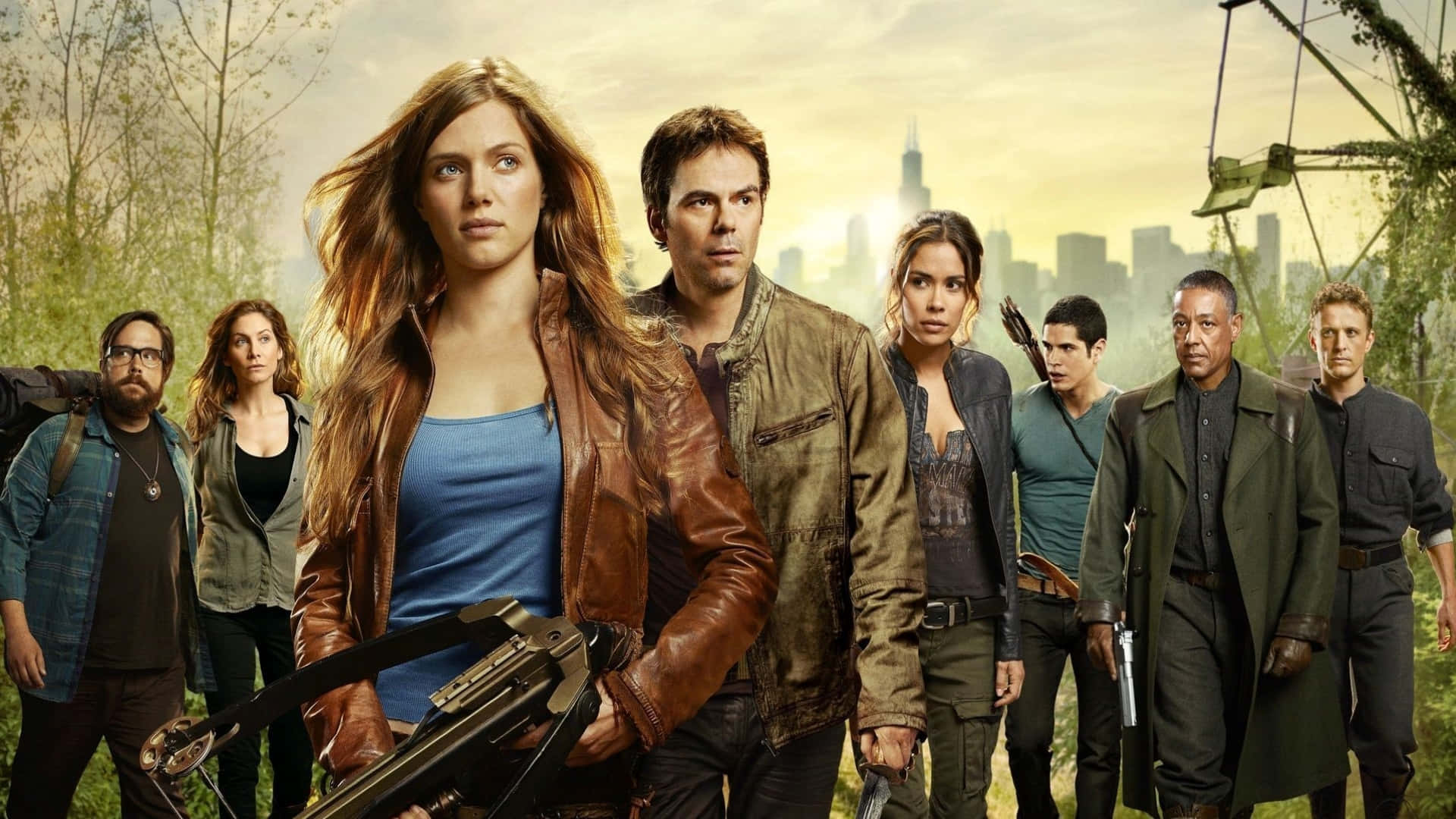 Tv Series 桌布 壁紙 — 一群七名身穿堅固裝備的倖存者警覺地站在森林中，背後是廢墟城市的天際線。