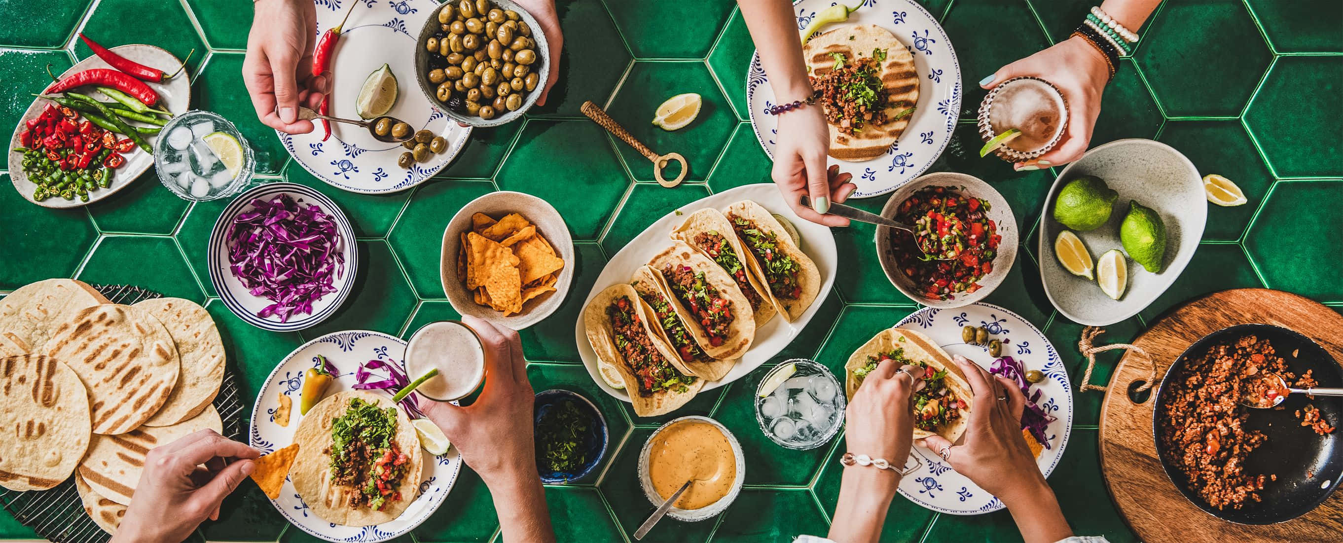 一群人在綠色瓷磚桌上進食 壁紙