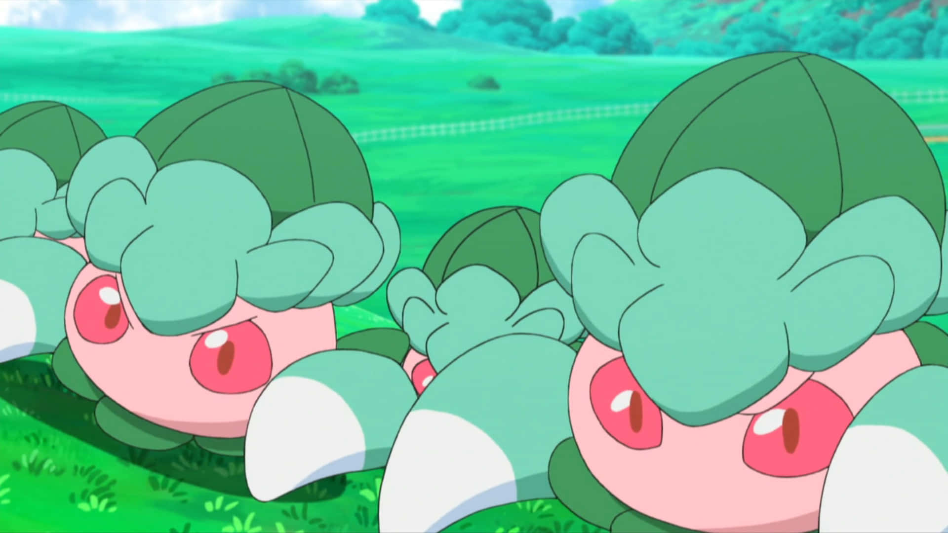 一群寶可夢 Fomantis 在草原上 壁紙 — 兩隻可愛的卡通喇叭芽從茂密的綠草中探出頭來，有著明亮的紅色眼睛和葉子帽子。