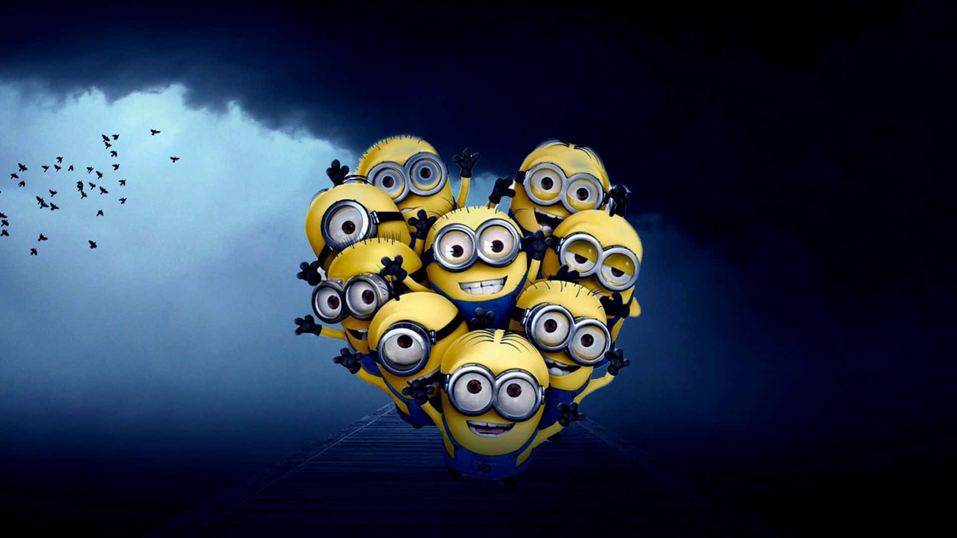 迷你兵團 桌布 壁紙 — 一群戴著護目鏡和藍色工裝褲的黃色Minions以心形聚集，站在木製碼頭上，天空風暴來襲，鳥兒向左飛翔。