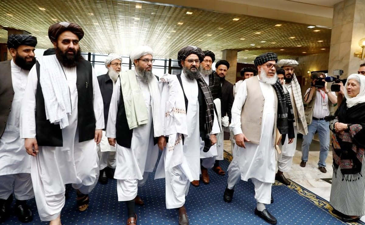 Taliban 桌布 壁紙 — 一群穿著傳統服飾的阿富汗男子走過宏偉的酒店大堂，攝影師們捕捉了這一刻。