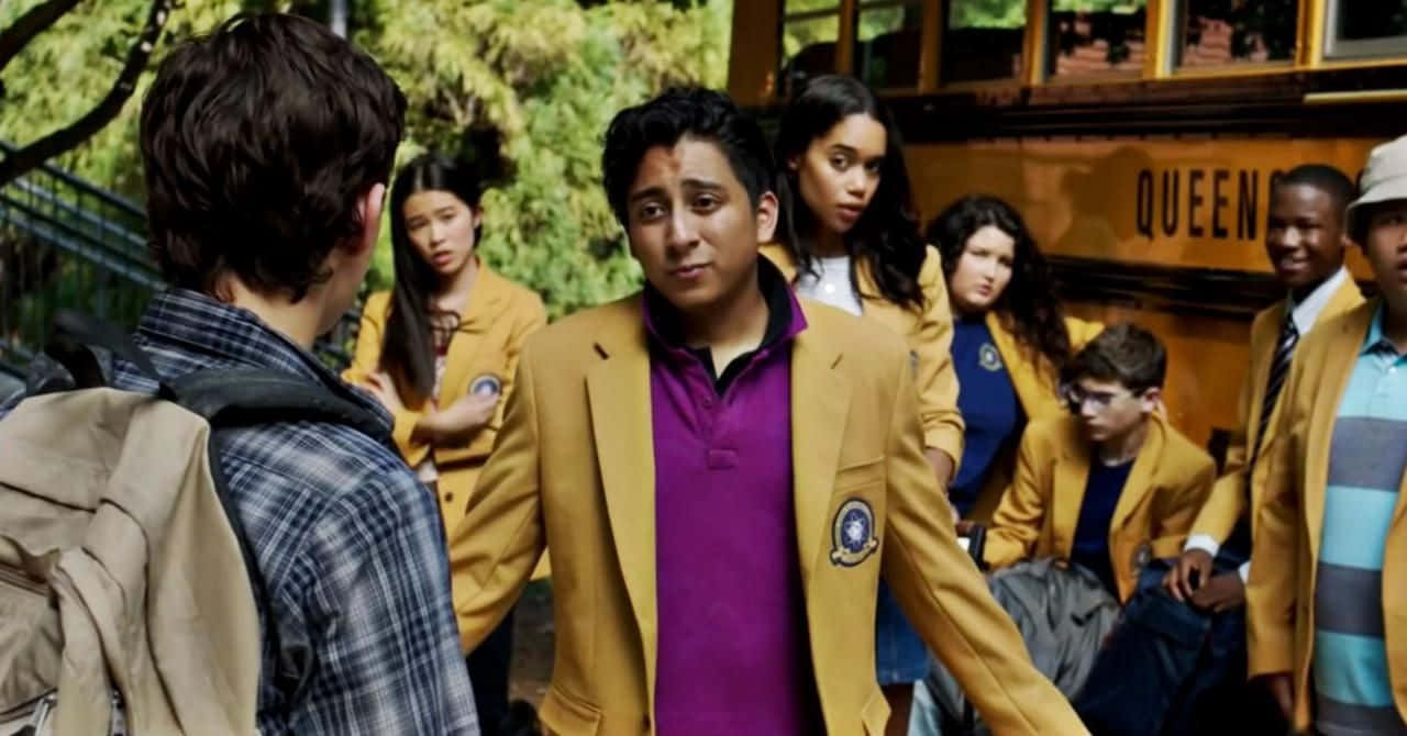 Flash Thompson 桌布 壁紙 — 一群穿著黃色外套的學生站在校車附近，其中一個穿著紫色襯衫的男孩面向另一個學生。