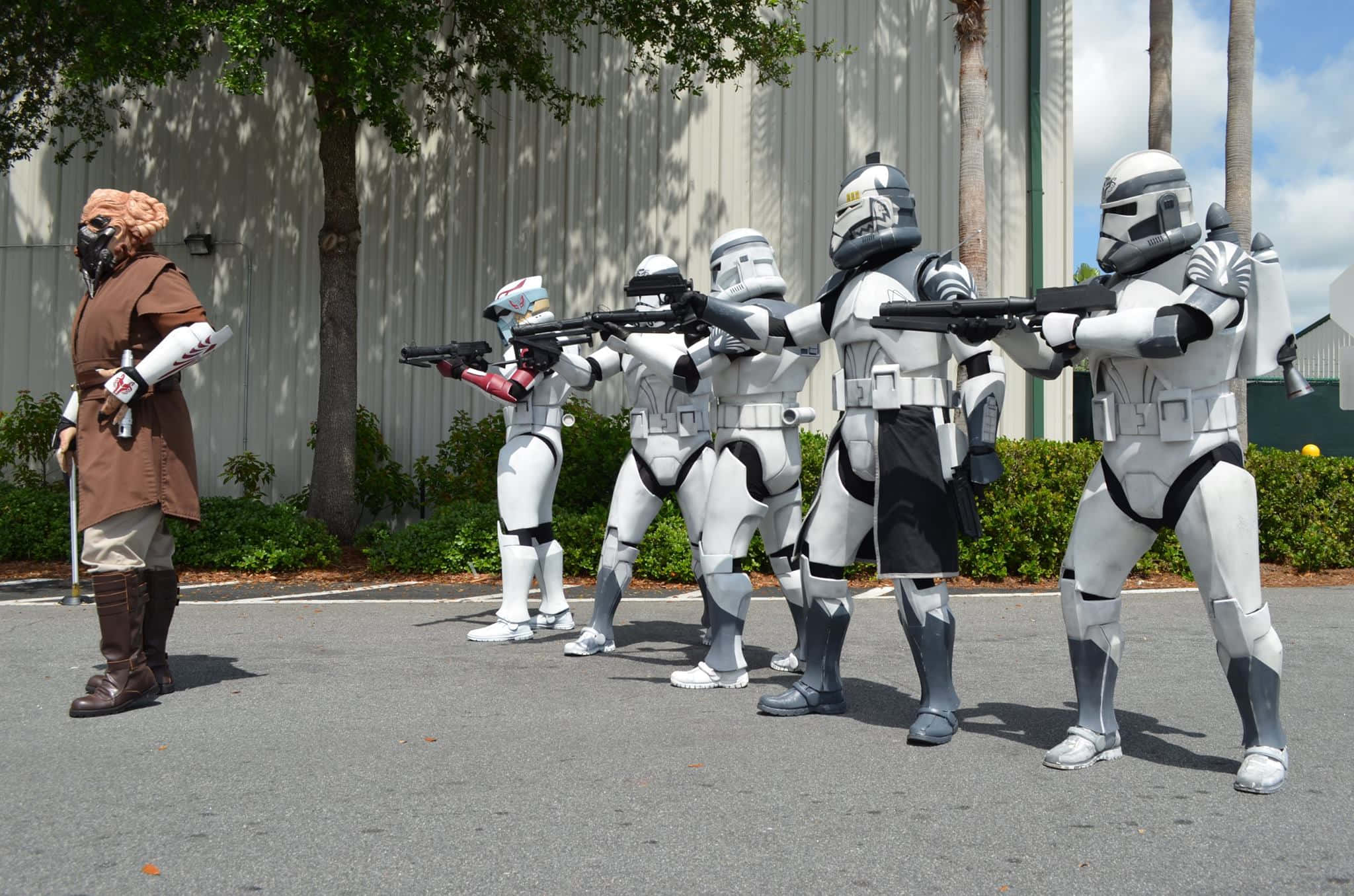 The Order 66 桌布 壁紙 — 一群身穿白色盔甲的星球大戰風暴兵在戶外向身穿棕色長袍的角色瞄準爆能槍。