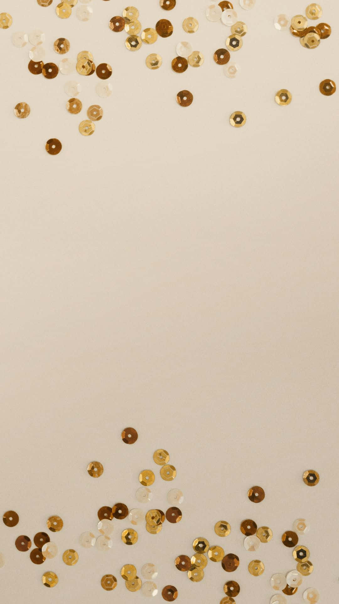 散落在米色表面上的金色和白色亮片，用於節日裝飾。