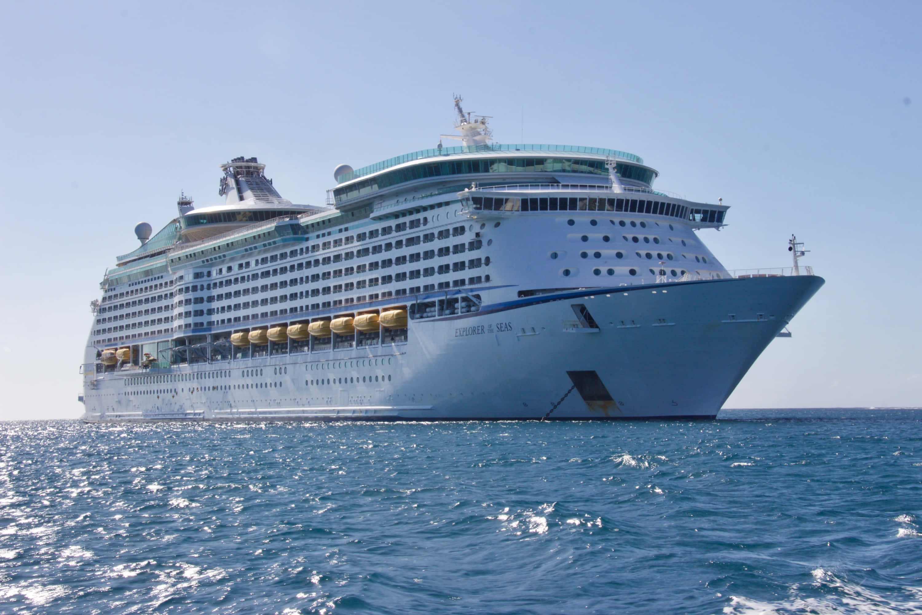 Ship 桌布 壁紙 — 一艘名為 Explorer of the Seas 的巨型白色郵輪在晴朗的天空下航行於閃閃發光的藍色海洋中。