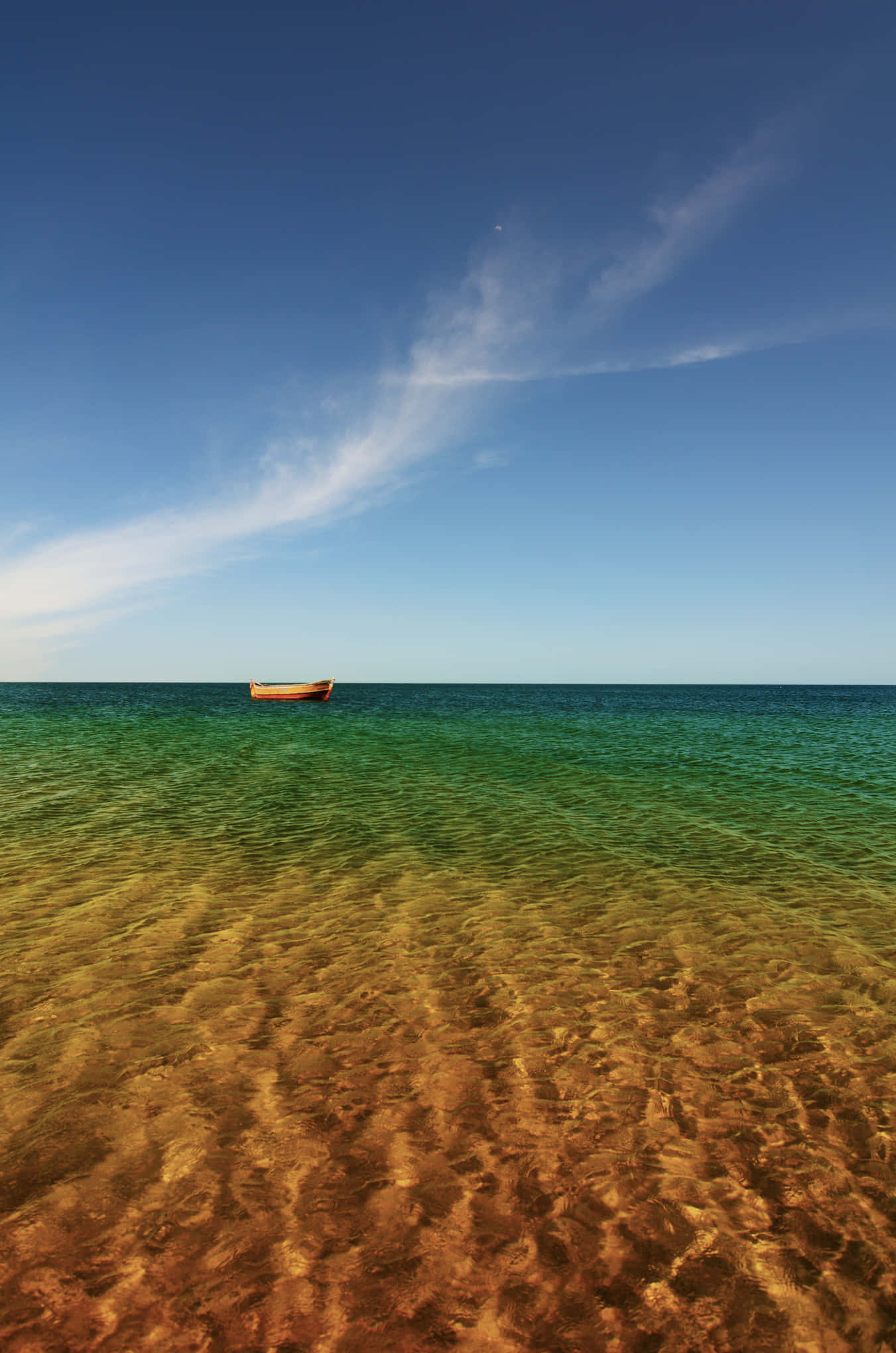 Beach Photography 桌布 壁紙 — 一艘孤獨的木船漂浮在清澈碧綠的水面上，金色沙底之上，廣闊藍天白雲之下。