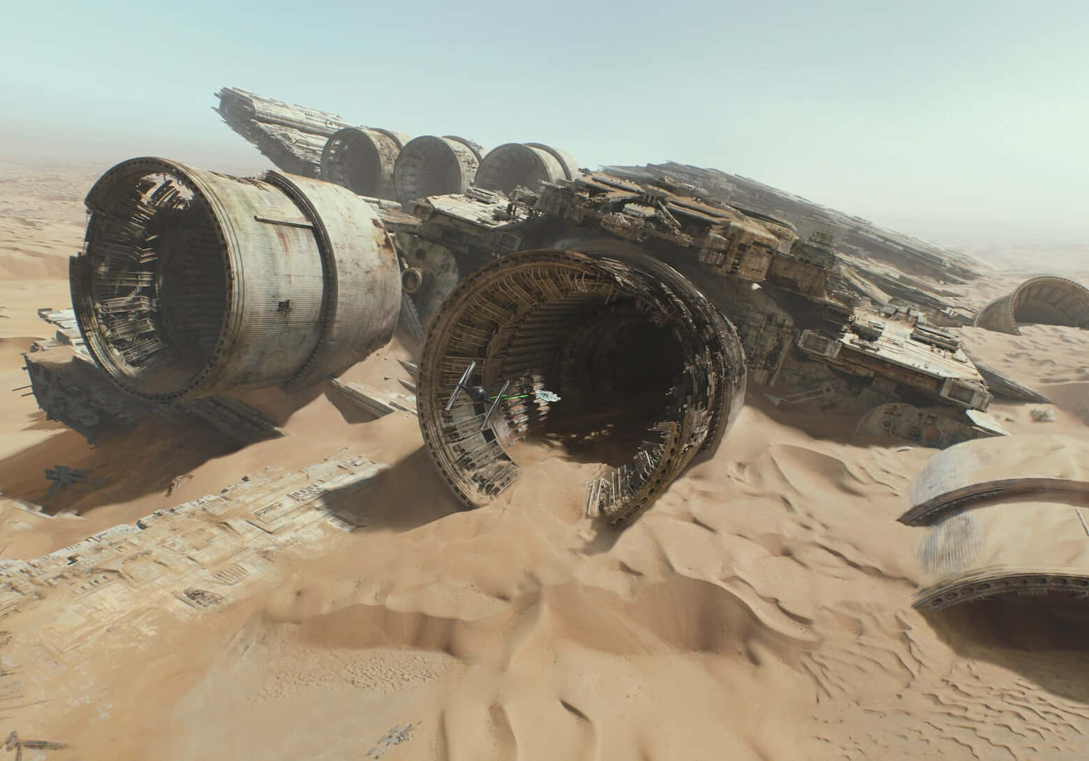 The Battle Of Jakku 桌布 壁紙 — 一艘巨大的墜毀太空船埋在廣闊的沙漠中，沙丘和破碎的金屬零件散落在朦朧的天空下。