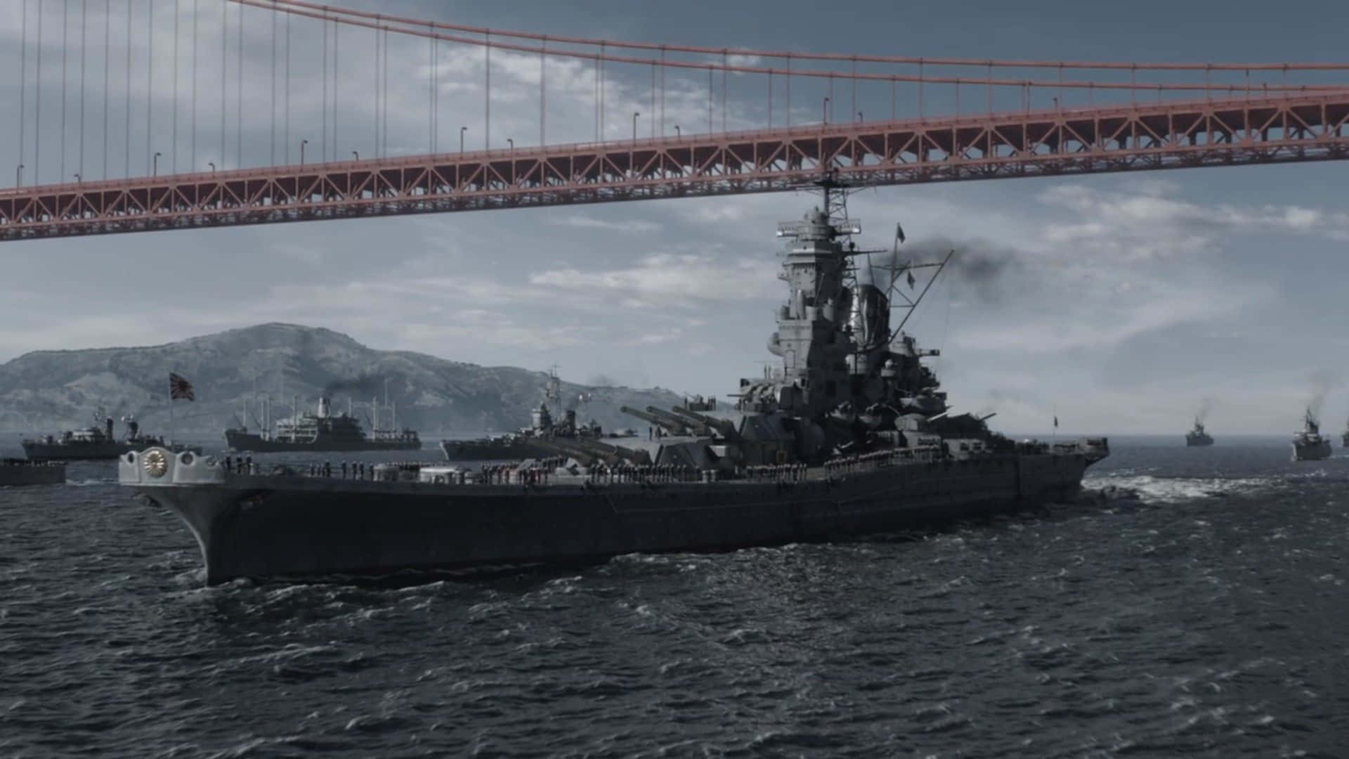  壁紙 — 一艘巨大的戰艦在陰天之下，於三藩市灣中其他軍艦的伴隨下，航行於標誌性的金門大橋下方。