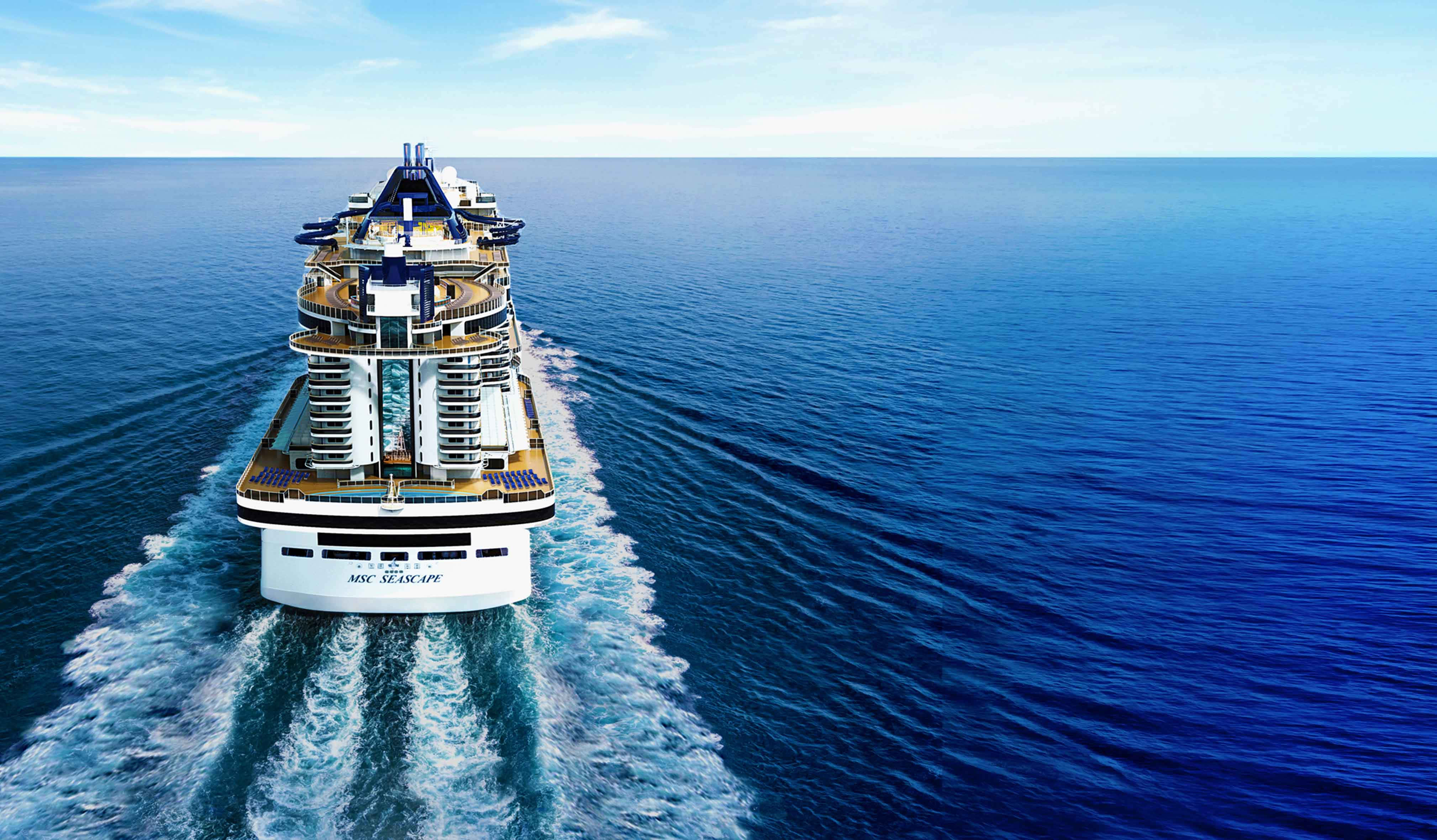 Cruise Ship 桌布 壁紙 — 一艘巨大的郵輪劃過深藍色的海水，在晴朗的天空下留下泡沫般的白色尾跡。