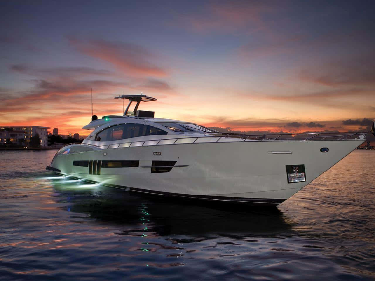 Yacht 桌布 壁紙 — 一艘時尚的白色豪華遊艇在平靜的水面上滑行，天空呈現出充滿活力的日落色彩，帶有橙色和紫色的雲彩。
