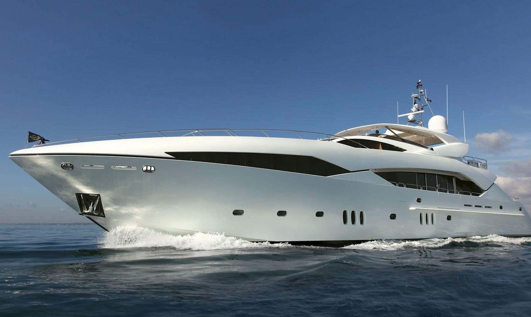 Yacht 桌布 壁紙 — 一艘時尚的白色豪華遊艇在晴朗的天空下劃過深藍色的海水。